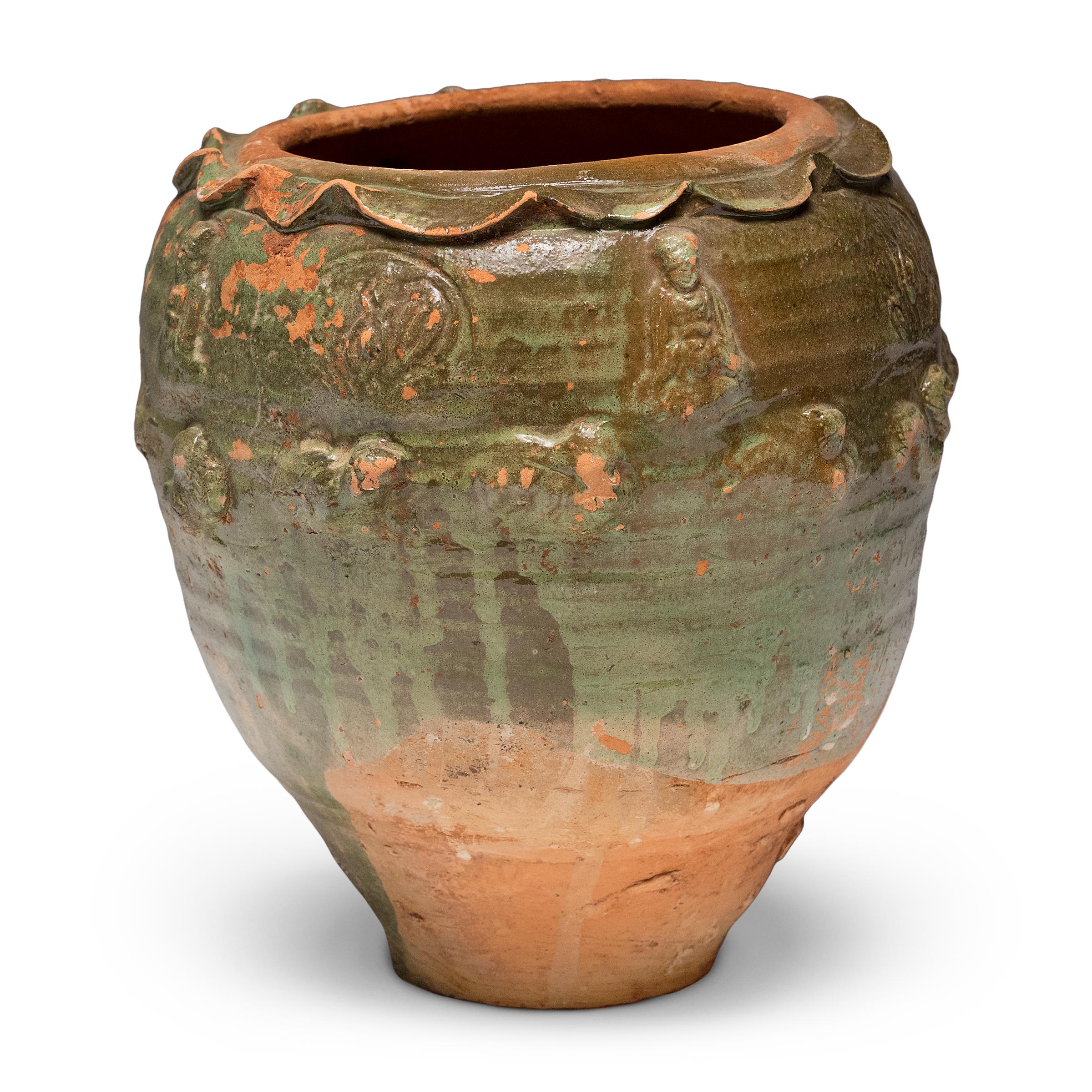 Beautiful in its imperfection, this green glazed jar from Yunnan province is an offering vessel, or spirit jar, originally filled with ritual offerings such as coins, shells, flowers and grains. Attributed to the Yuan dynasty (1271-1368) or earlier,
