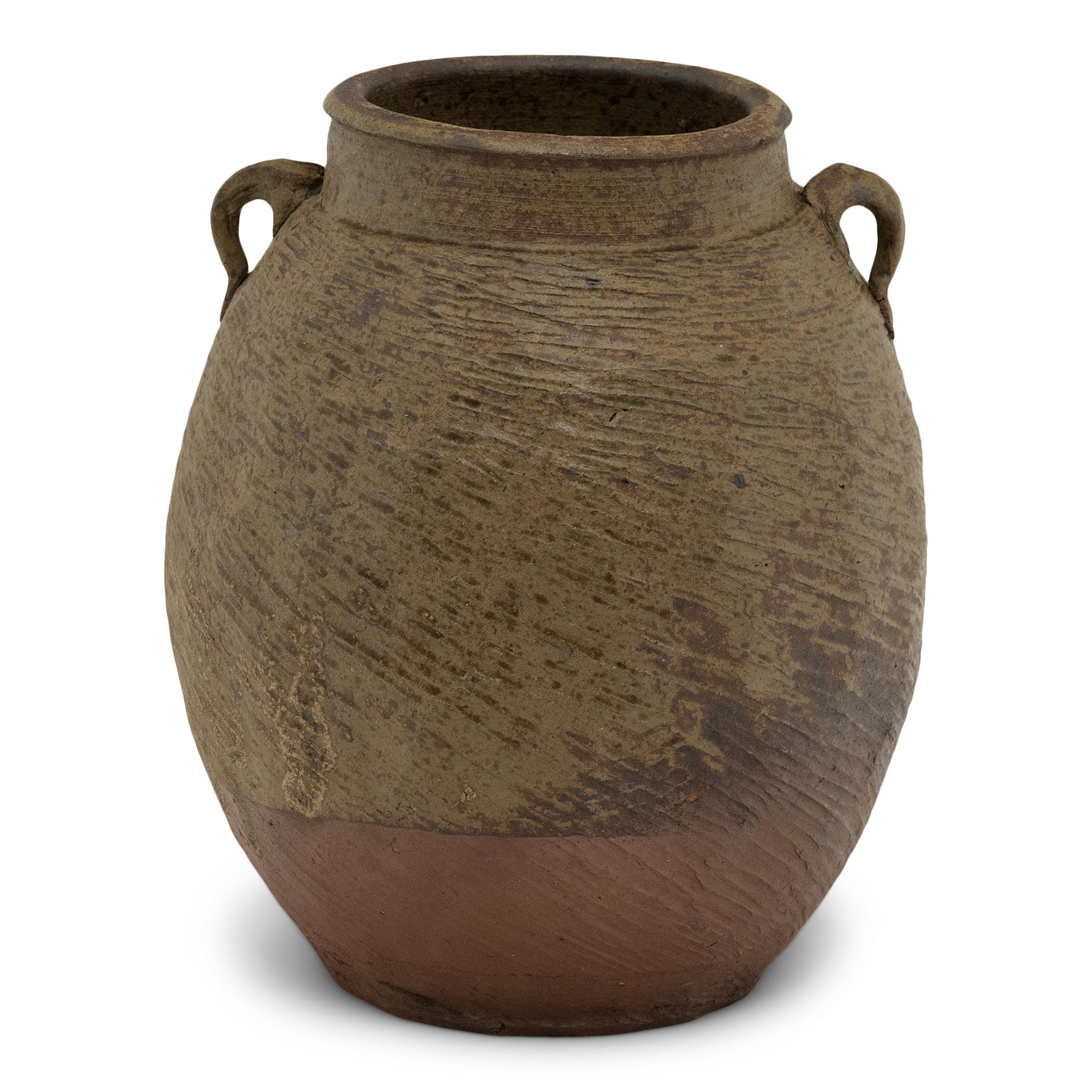 Charged with the humble task of storing dry goods, this small terracotta pot was hand-shaped in the 19th century with balanced proportions and a beautifully irregular brown-green slip finish. The lobed pot features a round form with a narrow base