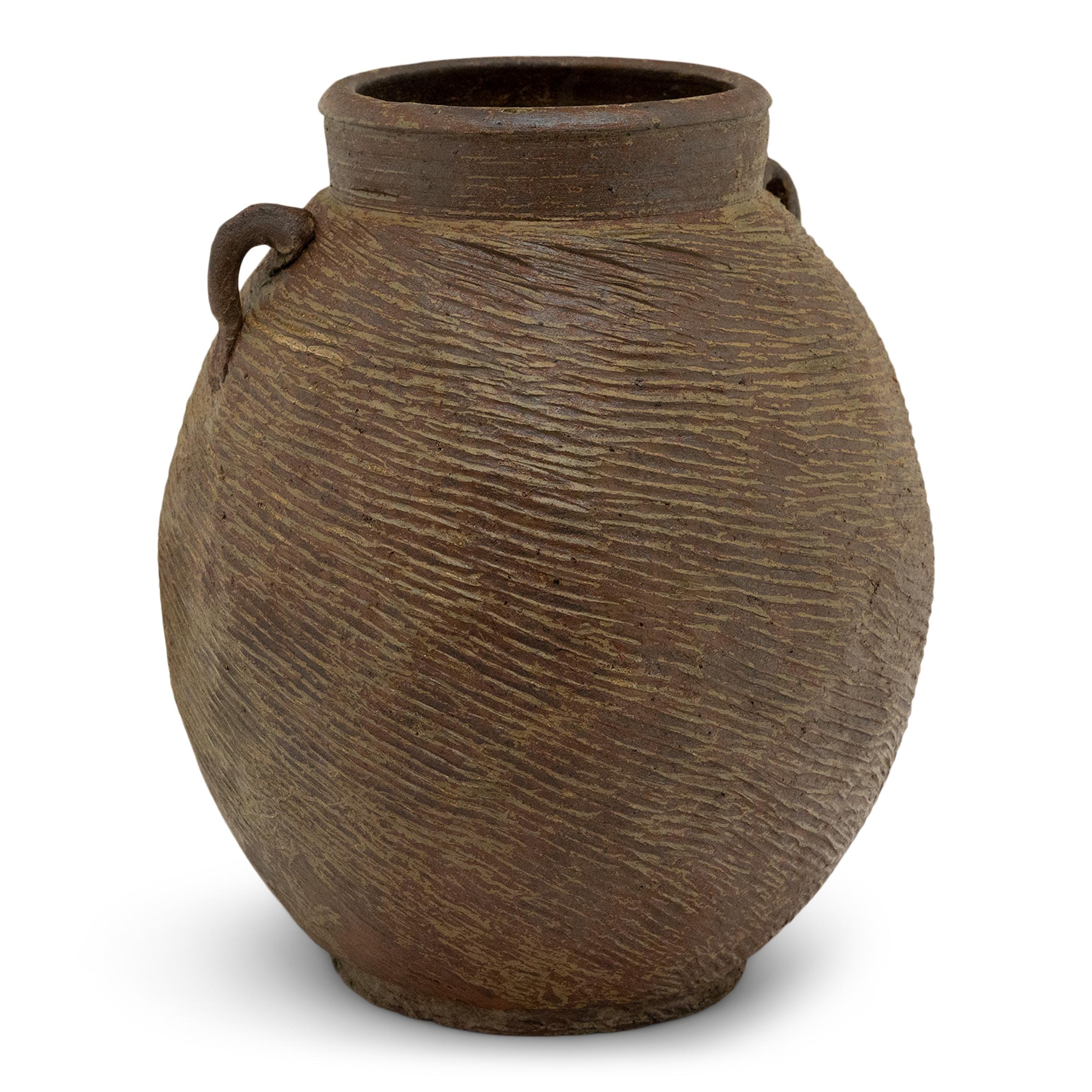 Rivestito da una splendida finitura irregolare in marroncino-verde, questo vaso in terracotta del XIX secolo aveva l'umile compito di conservare i prodotti secchi in una cucina della dinastia Qing. Il vaso lobato ha una forma rotonda con una base