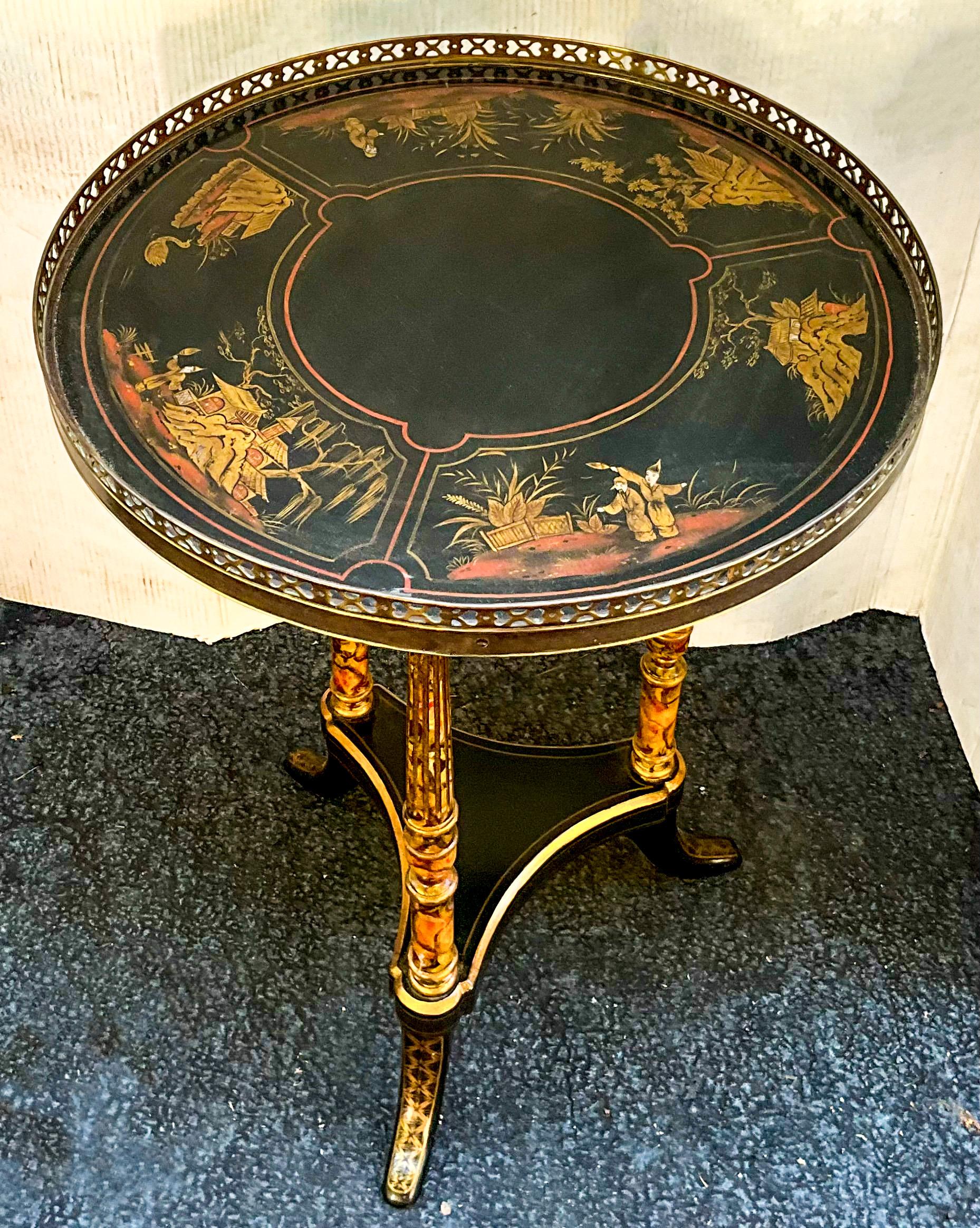 This side table checks all the boxes! It is a lovely drinks table with painted chinoiserie top surrounded by a brass gallery. The tripod legs are wood and have been hand painted faux marbleized finish. The base is black lacquer with gilt accents. It