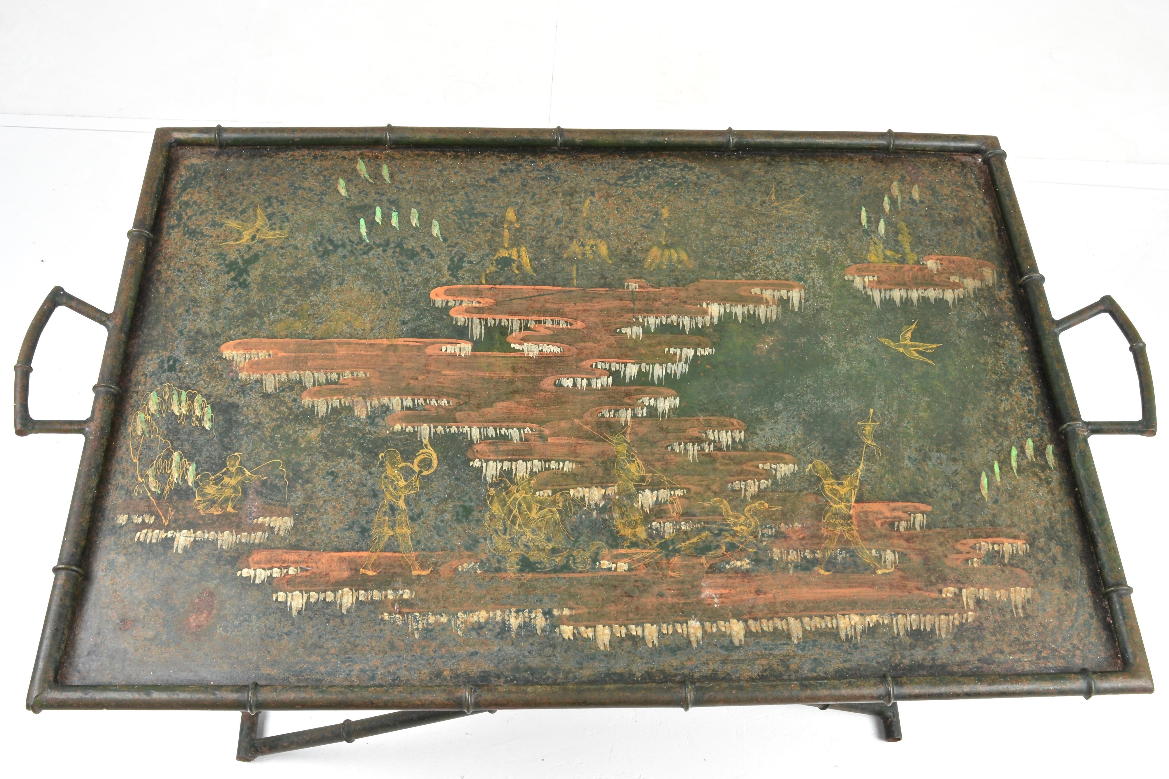 Hand painted chinoiserie scene on a large metal tray with two handles. Metal faux bamboo folding stand adjusts from a low cocktail table (14-16