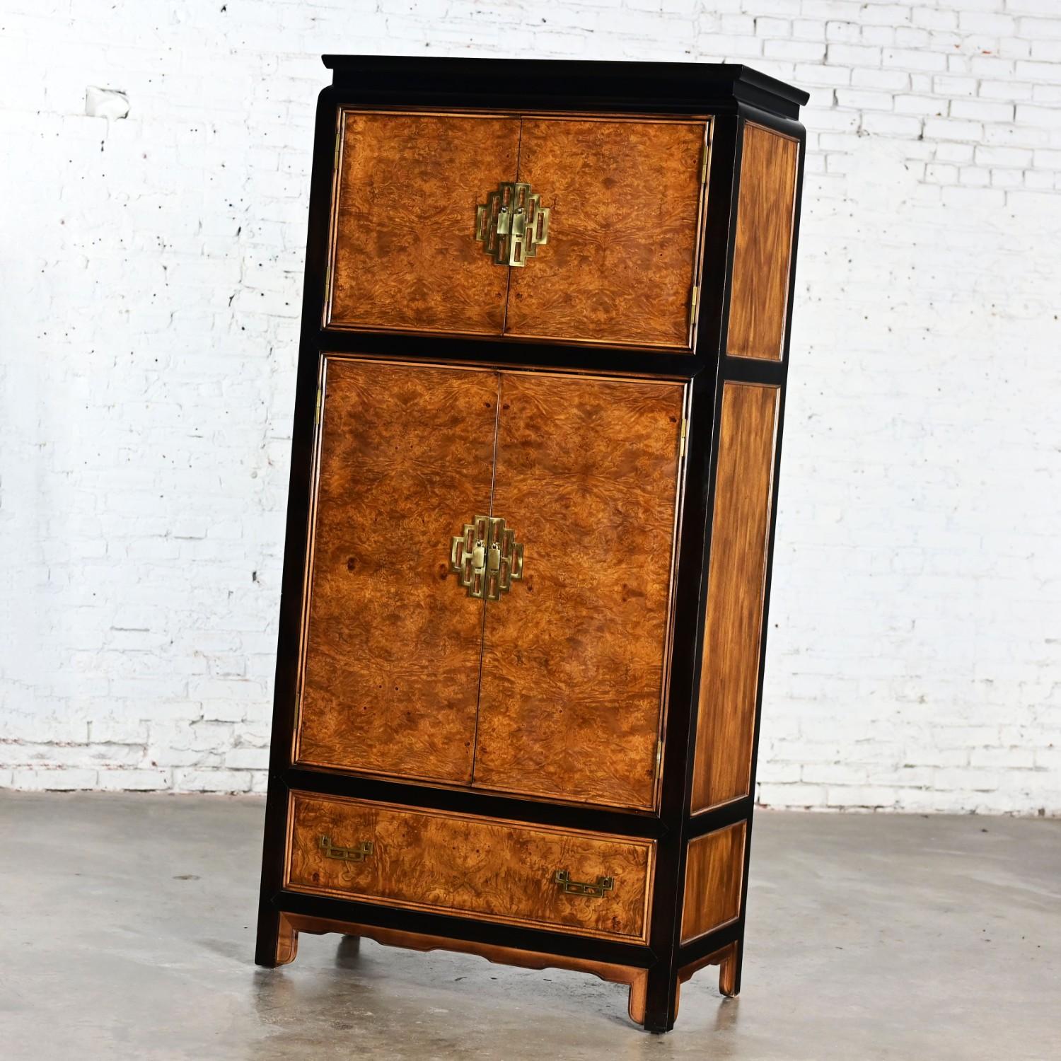 Handsome vintage Chinoiserie Chin Hua Collection armoire, wardrobe, or entertainment cabinet by Raymond K. Sabota for Century Furniture comprised of an ebony-tone wood frame, burlwood inlays, brass trim & hardware, upper & lower double doors, upper