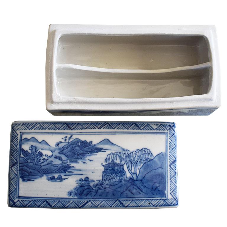 An exquisite long ceramic divided box with a lid. Decorated in a blue and white glaze, this long rectangular box features a divided interior. The exterior is glazed in blue and white and decorated with painted scenes of landscapes with pagodas and