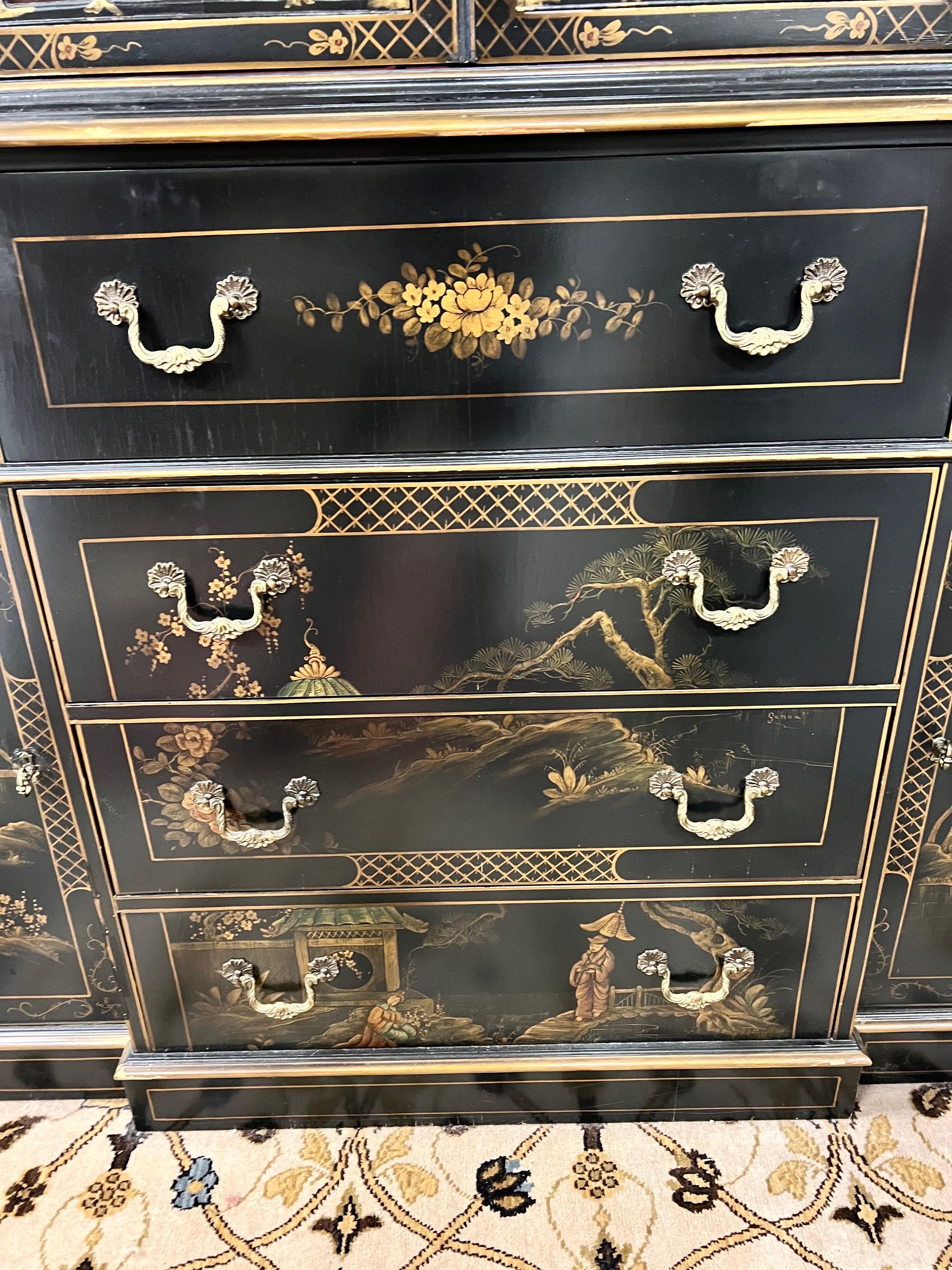 Elegant and sought after two piece chinoiserie black lacquered breakfront by Union National, NY circa 1950's. Come with top and bottom and is electrified. Features handpainted red interior and sought after black and gold chinoiserie style exterior