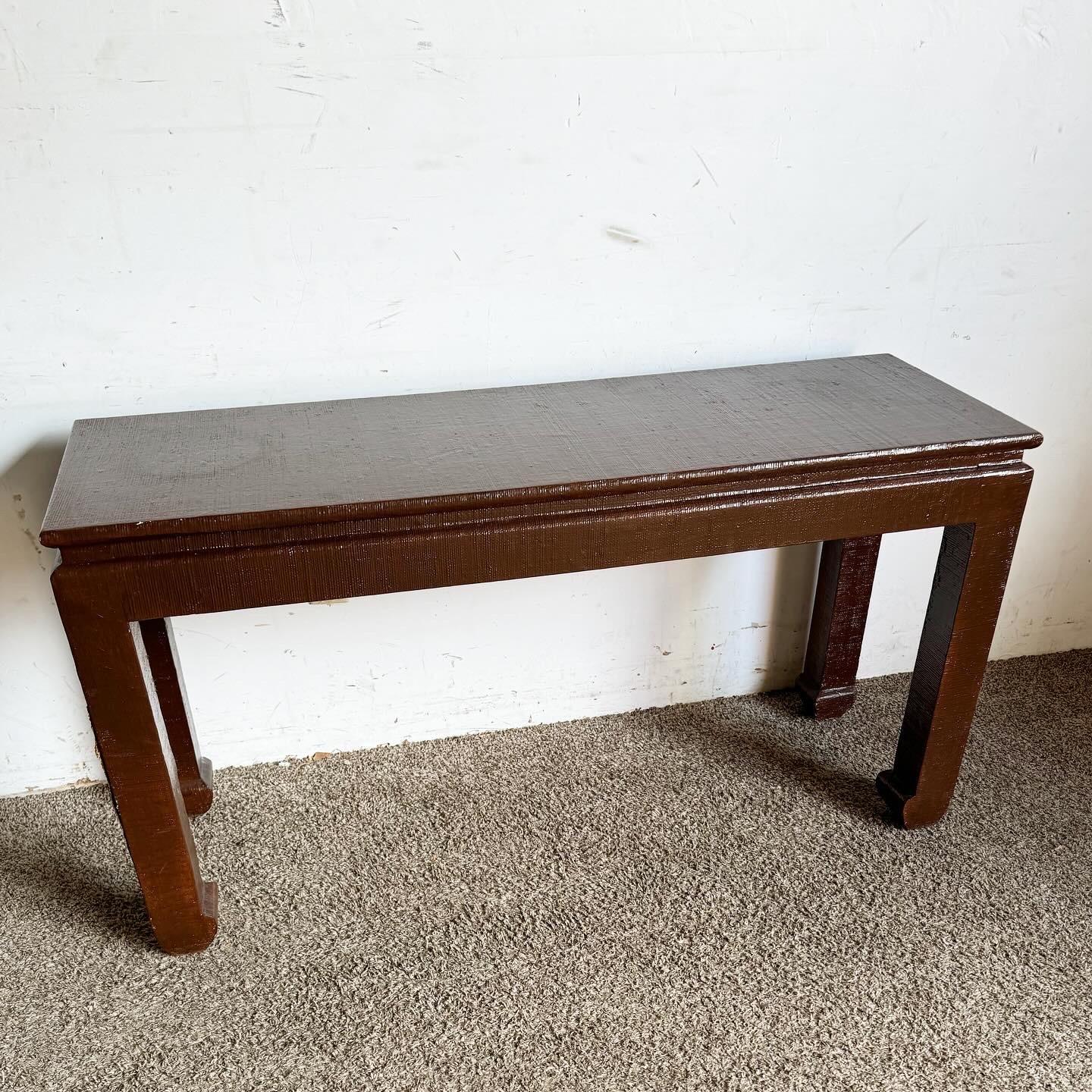 The Chinoiserie Brown Finished Grass Cloth Console Table adds natural elegance to your space. Covered in rich brown grass cloth, it offers unique texture and traditional craftsmanship. Perfect for showcasing collectibles or adding a warm ambiance to