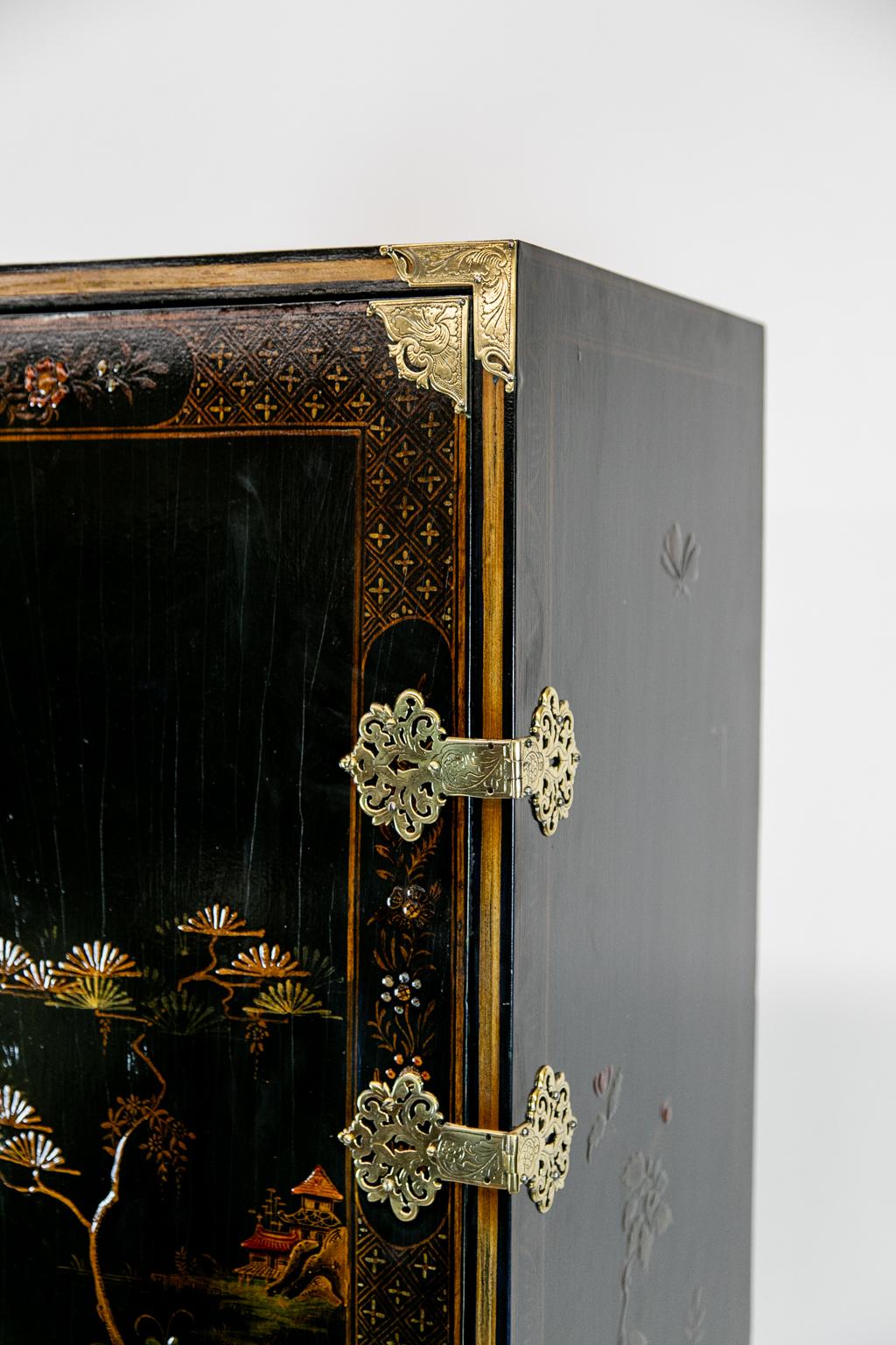 Chinoiserie cabinet on legs. This beautiful piece has the original engraved brass hinges and fittings. It sits on a cabriole leg stand. The interior has three shallow and three deep shelves.