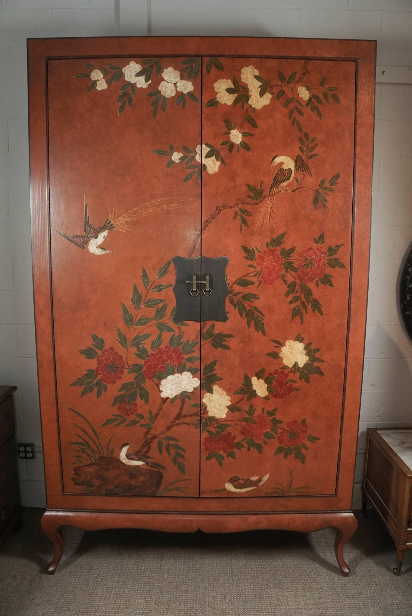 Here is a beautiful and monumental chinoiserie television cabinet with intricately hand-painted scenes of
birds and branches with flowers. The cabinet has full surround scenes on the exterior and is matched on the sides with an urn motif. The