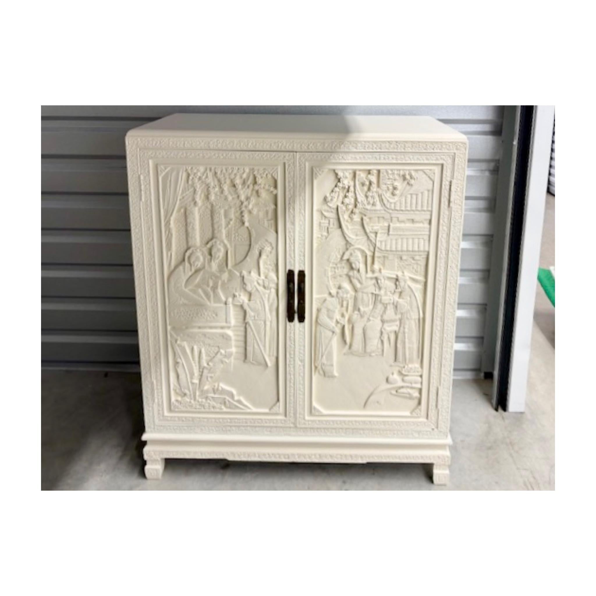 Armoire de chinoiserie lourdement sculptée avec des panneaux latéraux et des portes finement sculptés. L'intérieur comporte 5 tiroirs coulissants. Fraîchement laqué en blanc ivoire. Ajoutez un style chinois chic à votre projet de design.