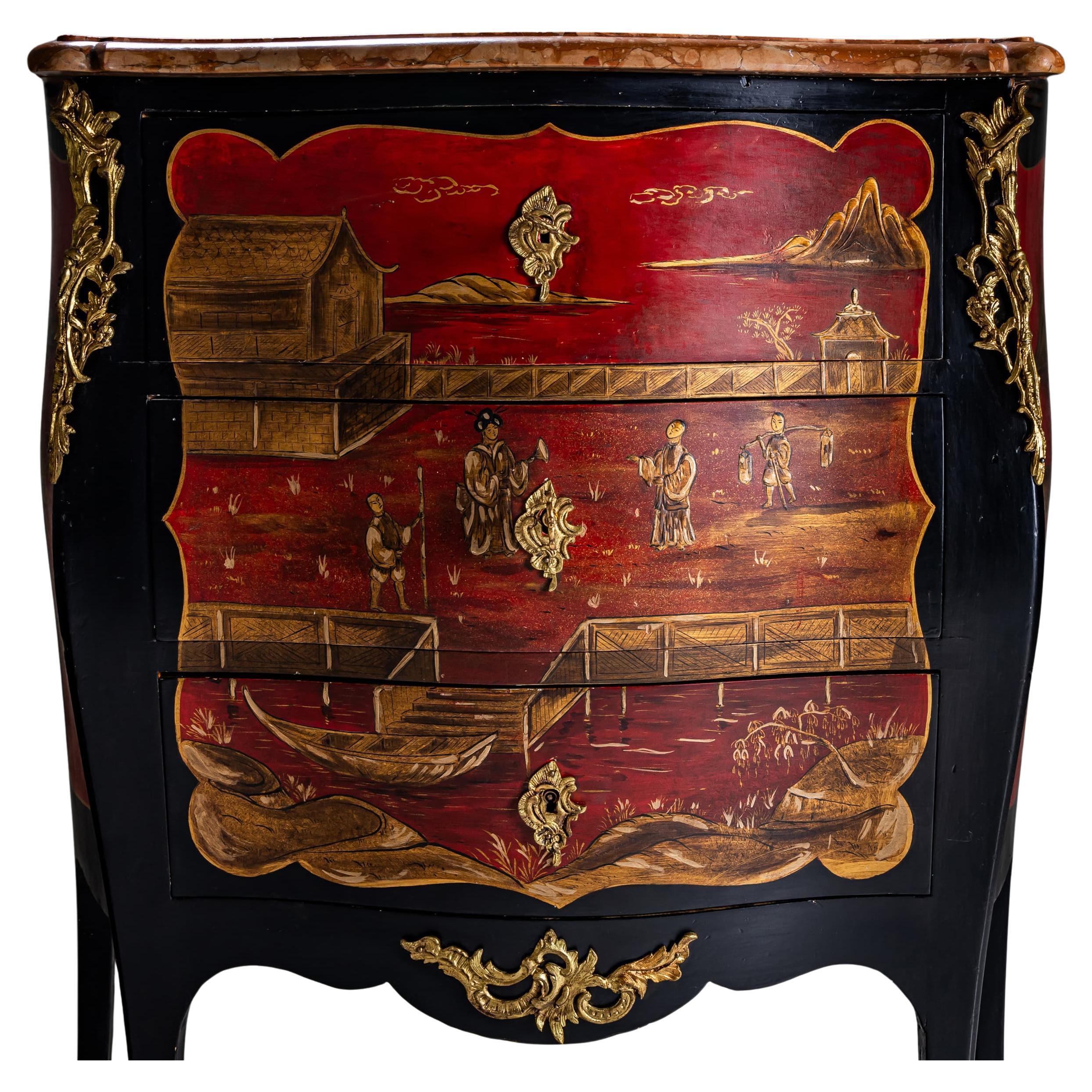 Elégante commode de style Louis XV datant de la première moitié du 20ème siècle. Le corps laqué noir est orné de cartouches courbes peintes en rouge, décorées de motifs en laque d'or dans le style Chinoiserie. En outre, le coffre est orné