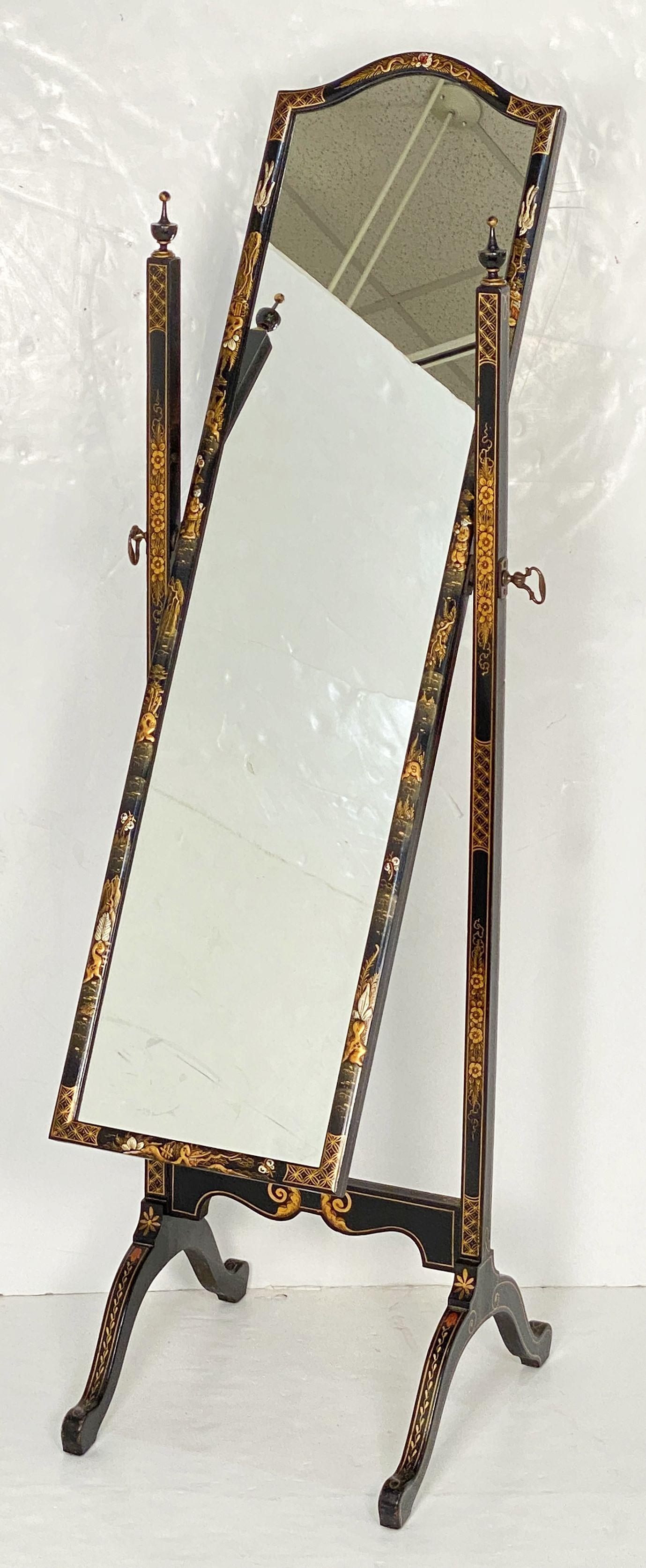 A beautiful English cheval mirror from the 19th century, featuring a black lacquered stretcher frame with finial decorations and raised chinoiserie designs around the whole and framed tilting mirror with decorative brass mirror mount