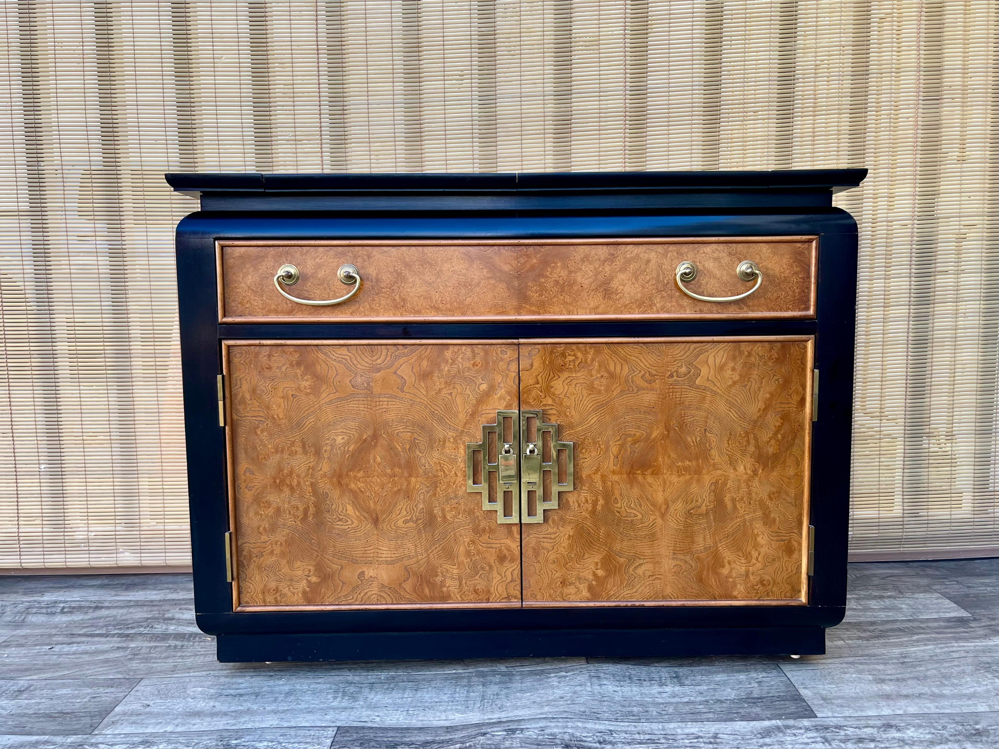 Buffet / serveur Vintage Mid Century Chin Hua Chinoiserie par Raymond Sobota pour Century Furniture. Circa 1960s
Placages d'érable ronce, dos fini, laque noire, quincaillerie en laiton, surface dure noire incrustée sous le plateau rabattable, un