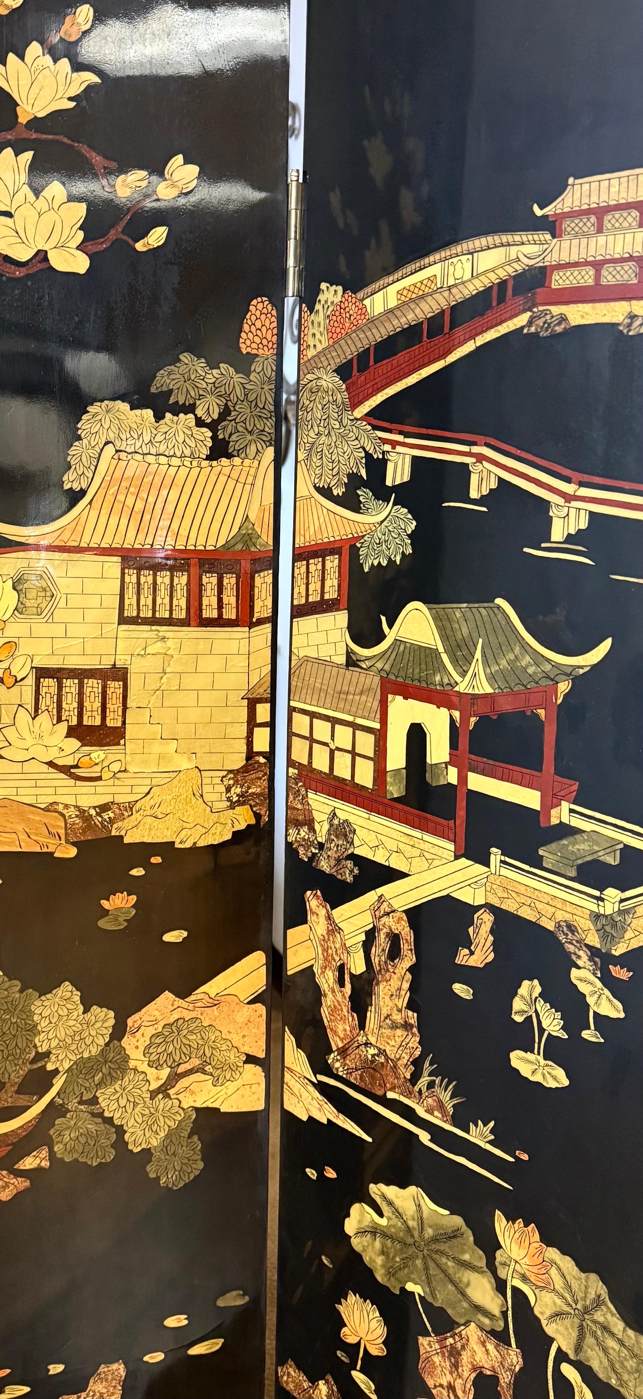 Stunning, expandable Chinese four panel screen/room divider with hand painted landscape scenery on black lacquered wood.  A monochromatic floral and bird motif is softly painted on the reverse side.  Features brass plated feet.  Use as a room