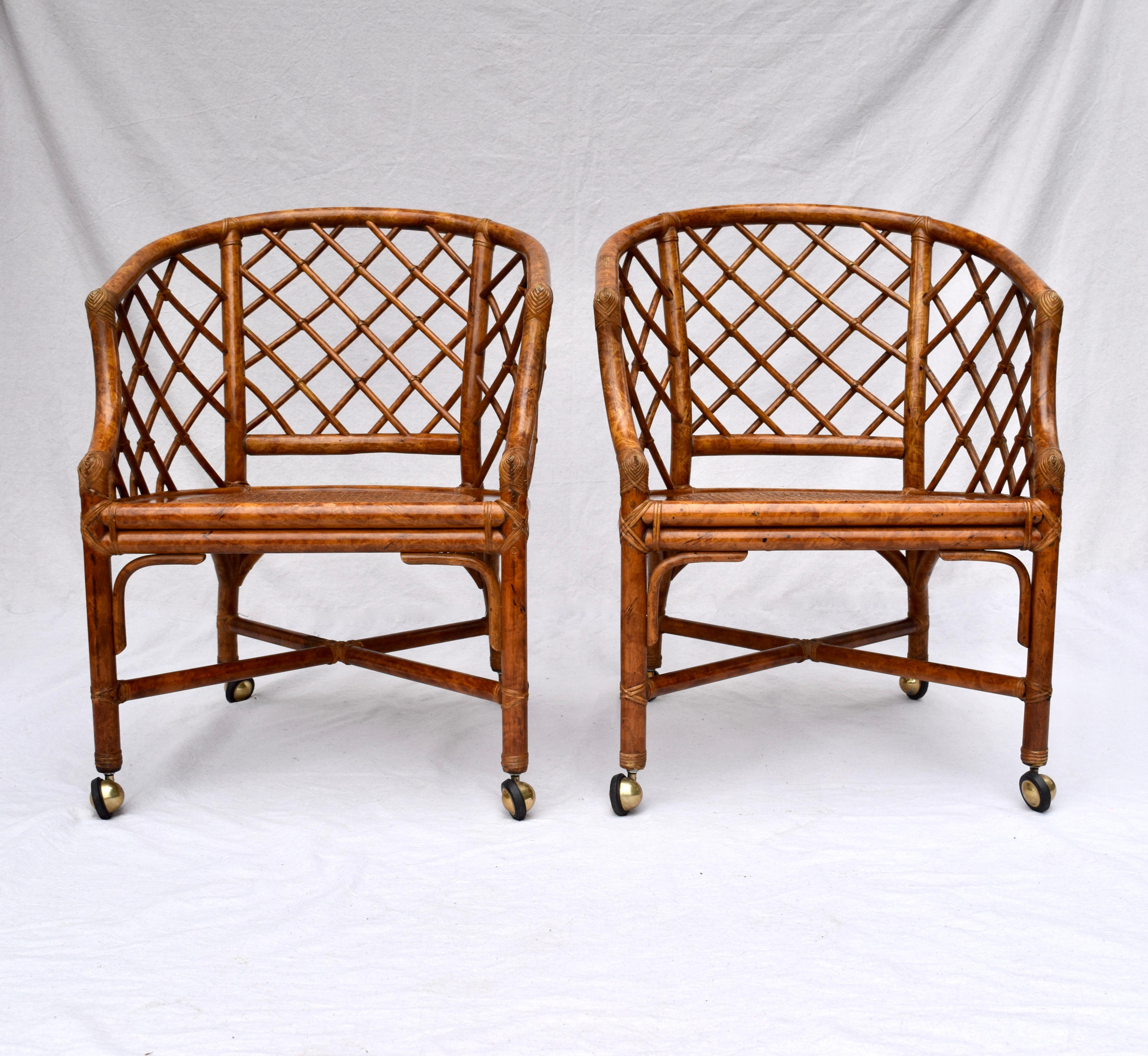 A pair of bent bamboo Chinese Chippendale barrel chairs on brass casters attributed to Ficks Reed. Lovely caned seats are enhanced with new cushions rich in indigo, persimmon and antique white tones in needlepoint tapestry textured woven upholstery.