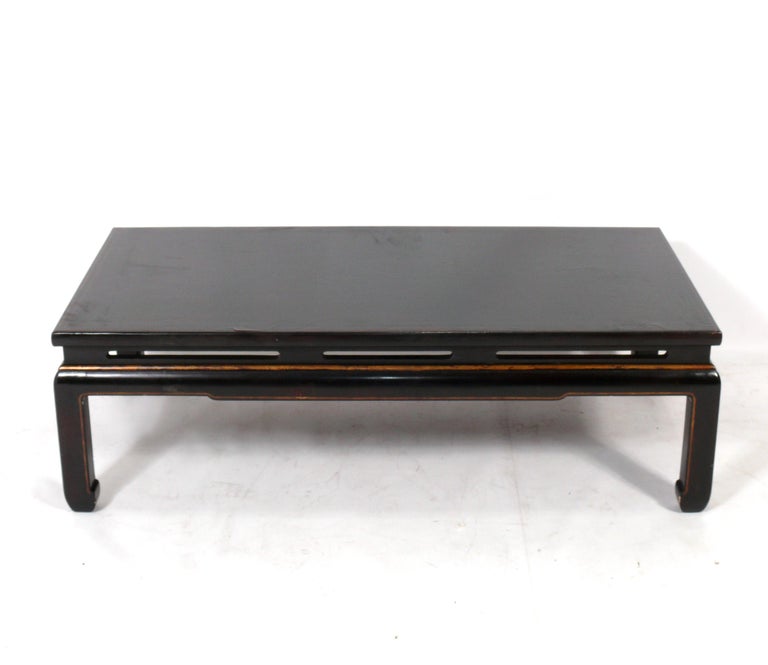 Chinoiserie coffee table in deep brown lacquer, probably Chinese or Japanese, circa 1950s. It exhibits a wonderful original surface with overall craquelure to the lacquer finish that only comes with age.