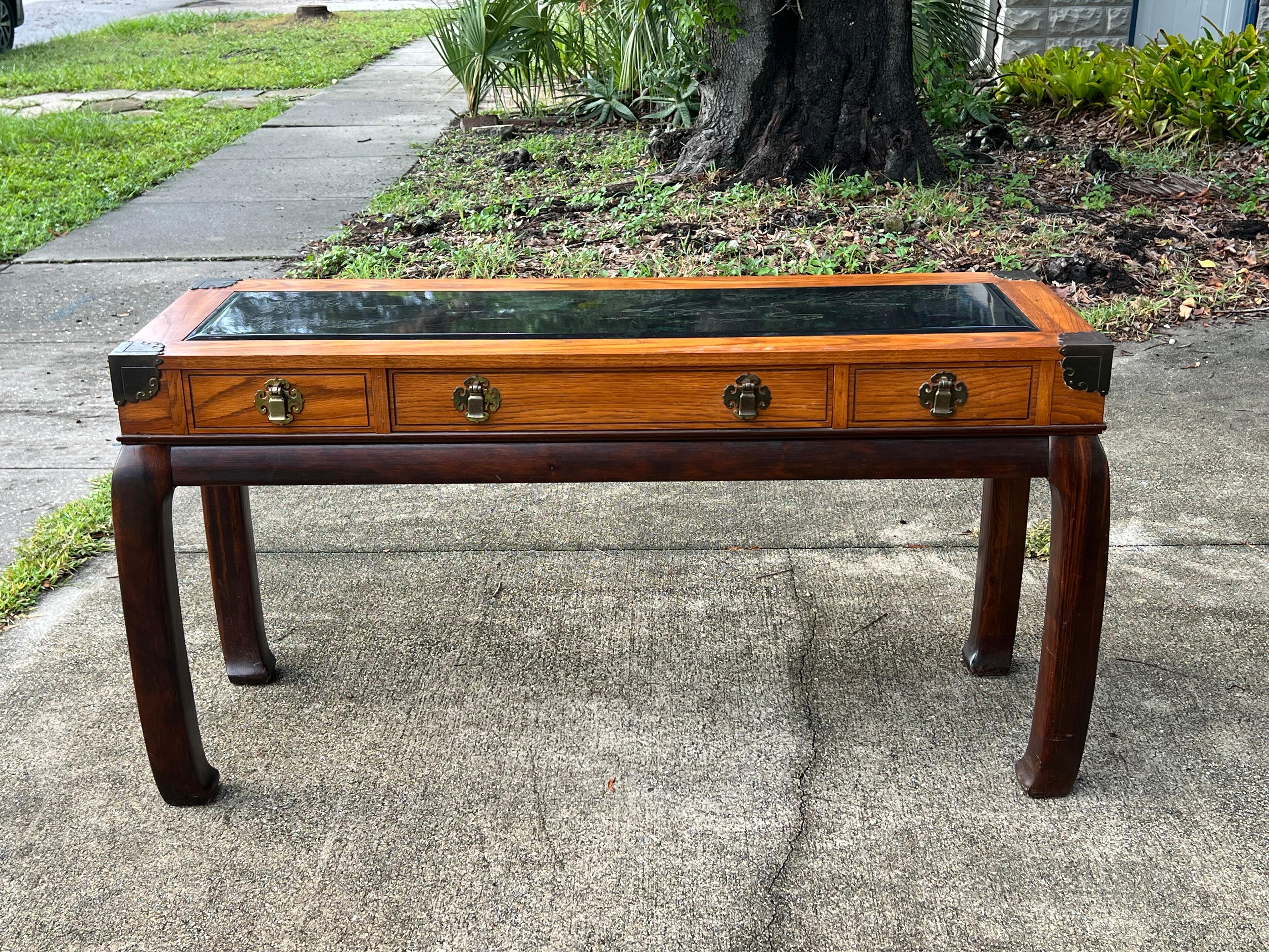 Consola clásica de estilo Chinoiserie de Bassett, fabricada en EE.UU. hacia 1970. Distintivas patas acampanadas, encimera de cristal grabado con motivos decorativos, cajón central extraíble. Acabado en la espalda: un bonito detalle.