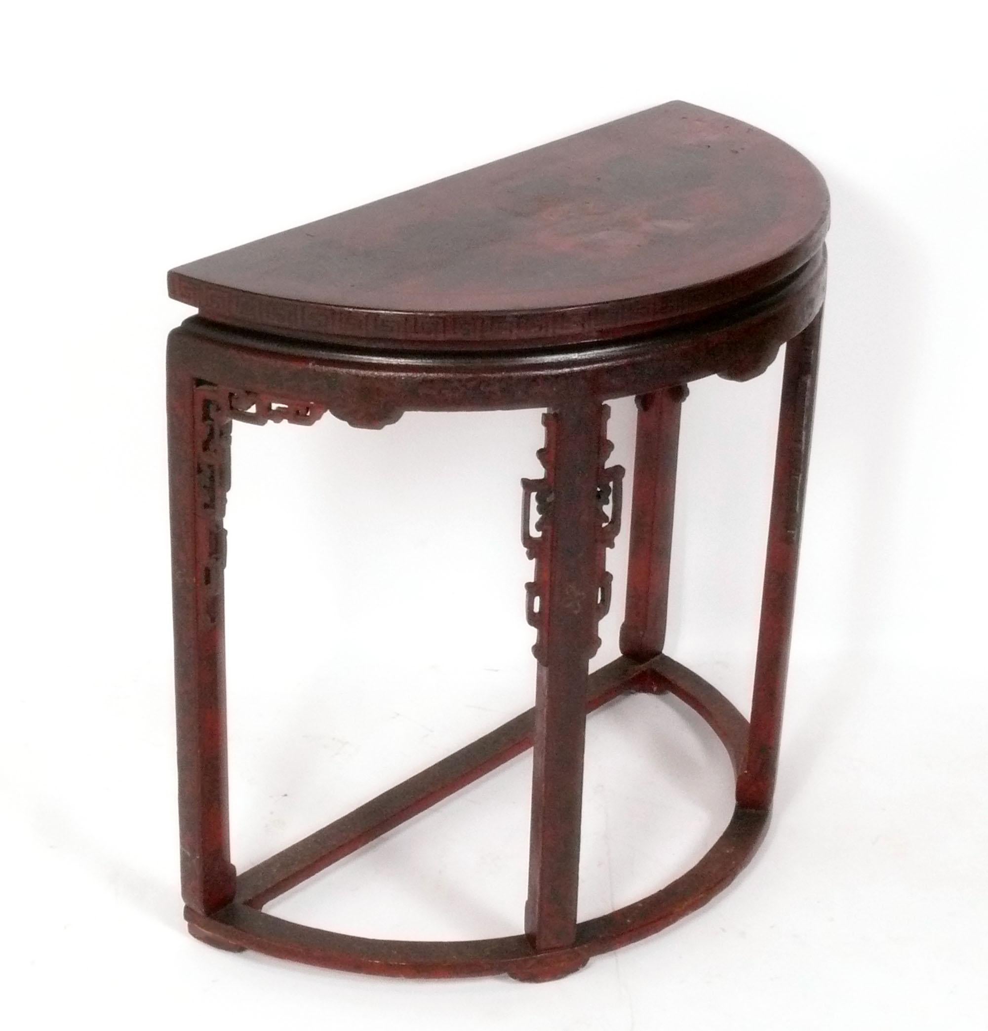Elegant Chinoiserie Console Table, probablement américain, circa 1960s. De taille polyvalente, elle peut être utilisée comme table de console, table d'entrée ou bar. Couleur rouge chinois profond avec décoration sculptée et peinte à la main et