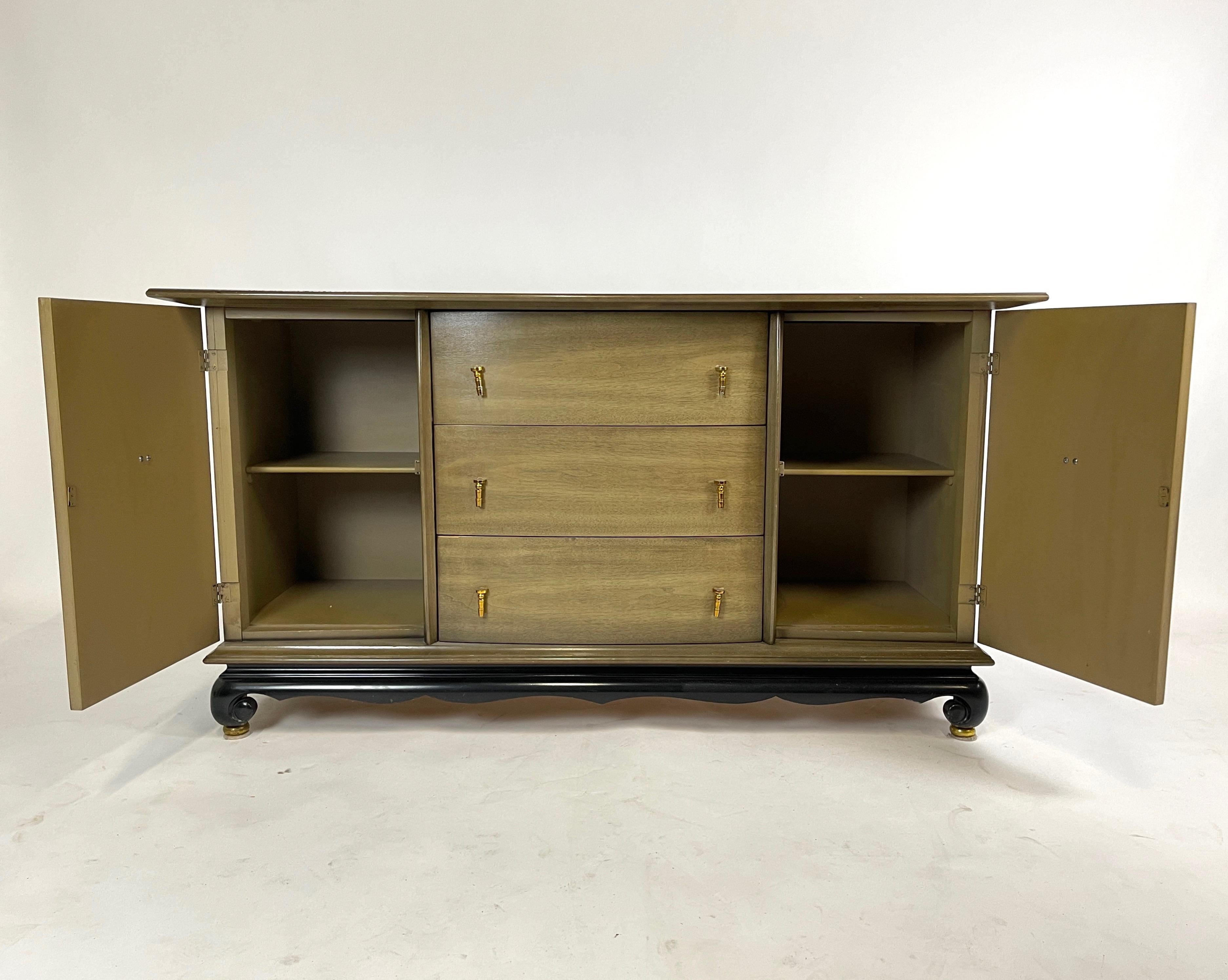 Elegant unattributed sideboard. Each drawer has 2 hanging tassel style gold pulls and the doors have a gold medallion with tassel pull.



 