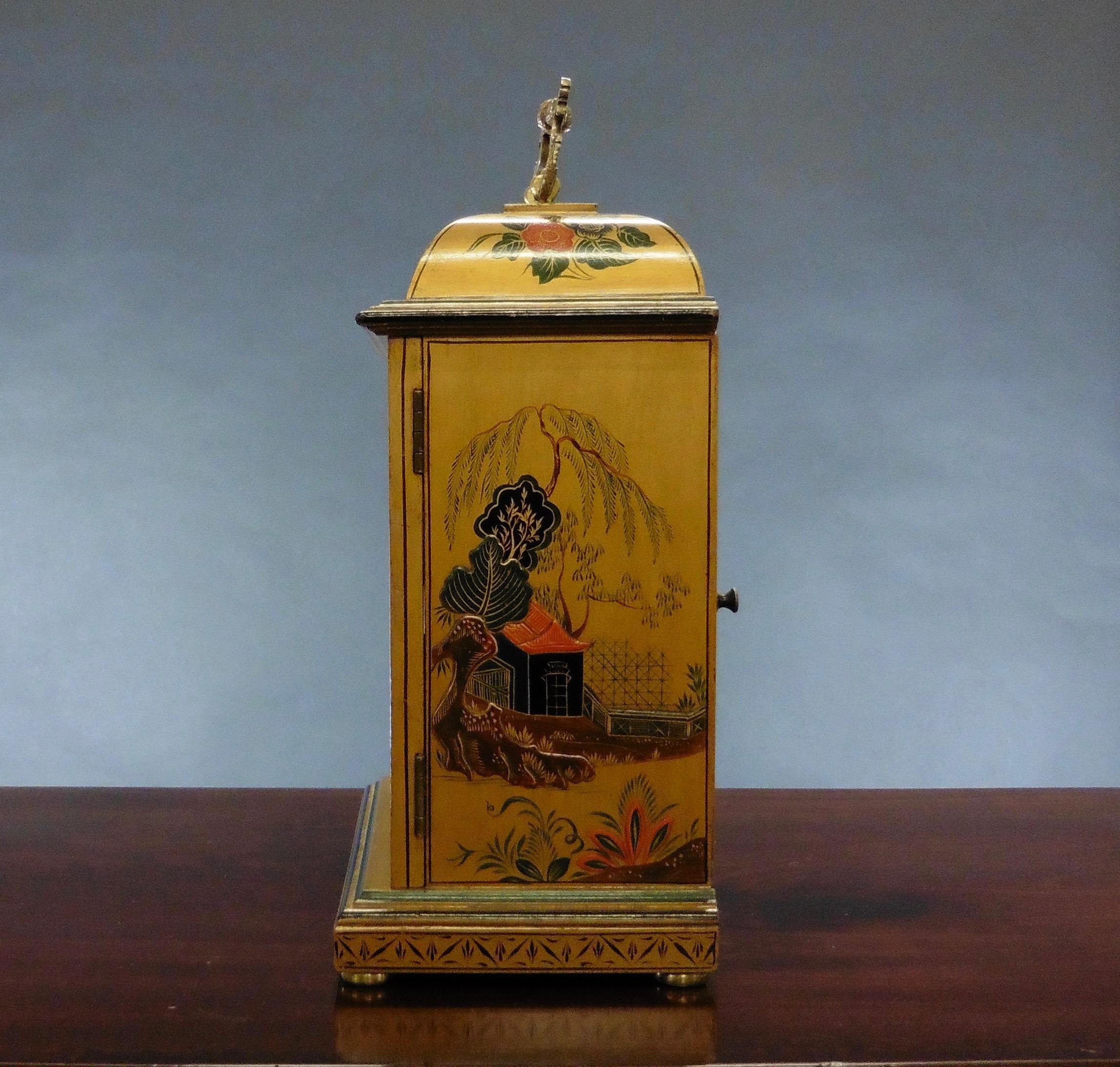 Fine bell top mantel clock standing on a raised, moulded plinth and resting on brass bun feet with ornate brass carrying handle. 

Beautifully decorated case with chinoiserie work on a gilded ground. Silvered chapter ring with Roman numerals and