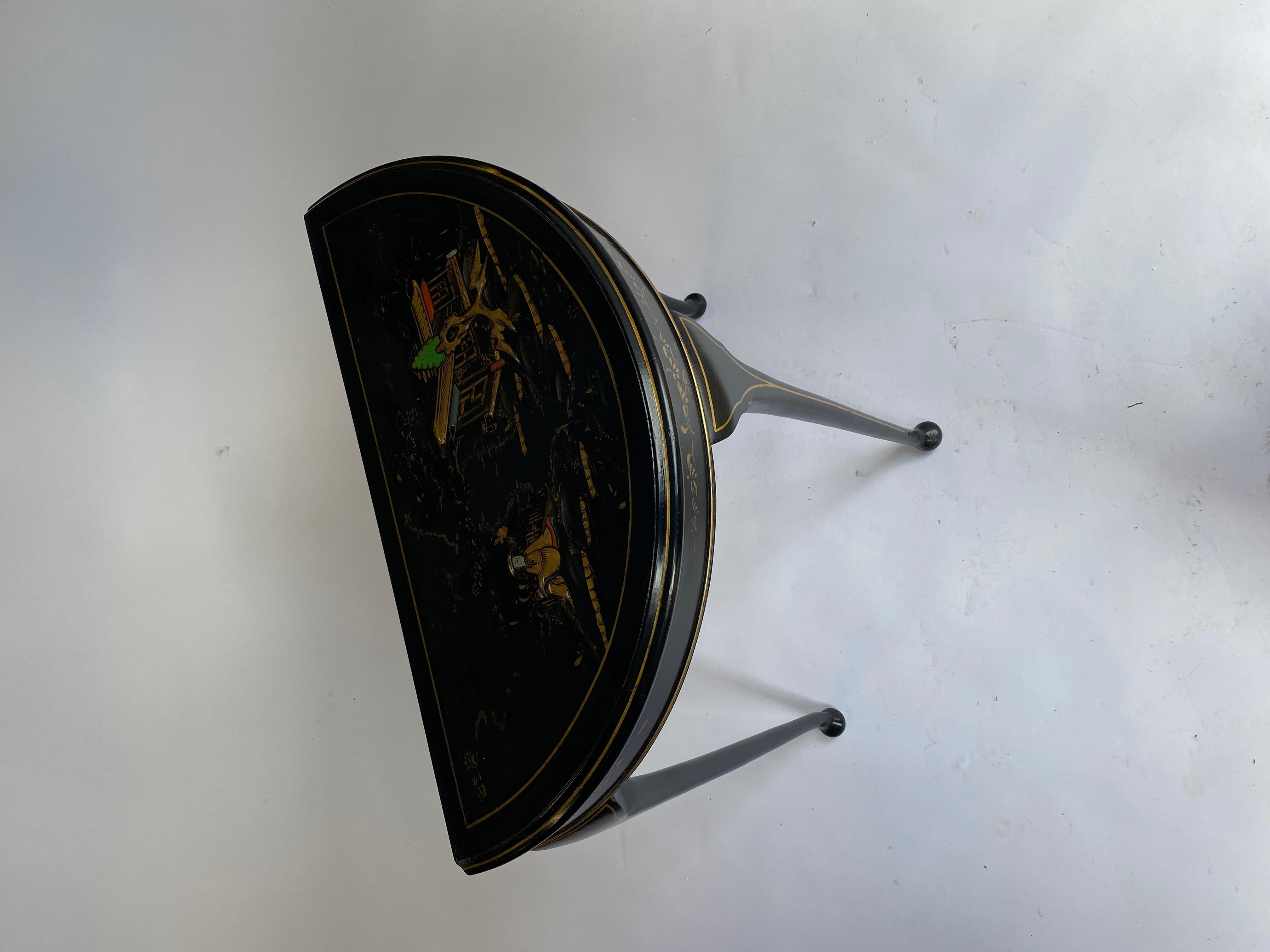 Cineserie  Tavolo consolle decorato a forma di Demi Lune
Colore nero e oro, 
Raffigurante : Figura, casa, alberi e fogliame
Siede su 3 gambe a forma di cabriole
Buone condizioni originali
