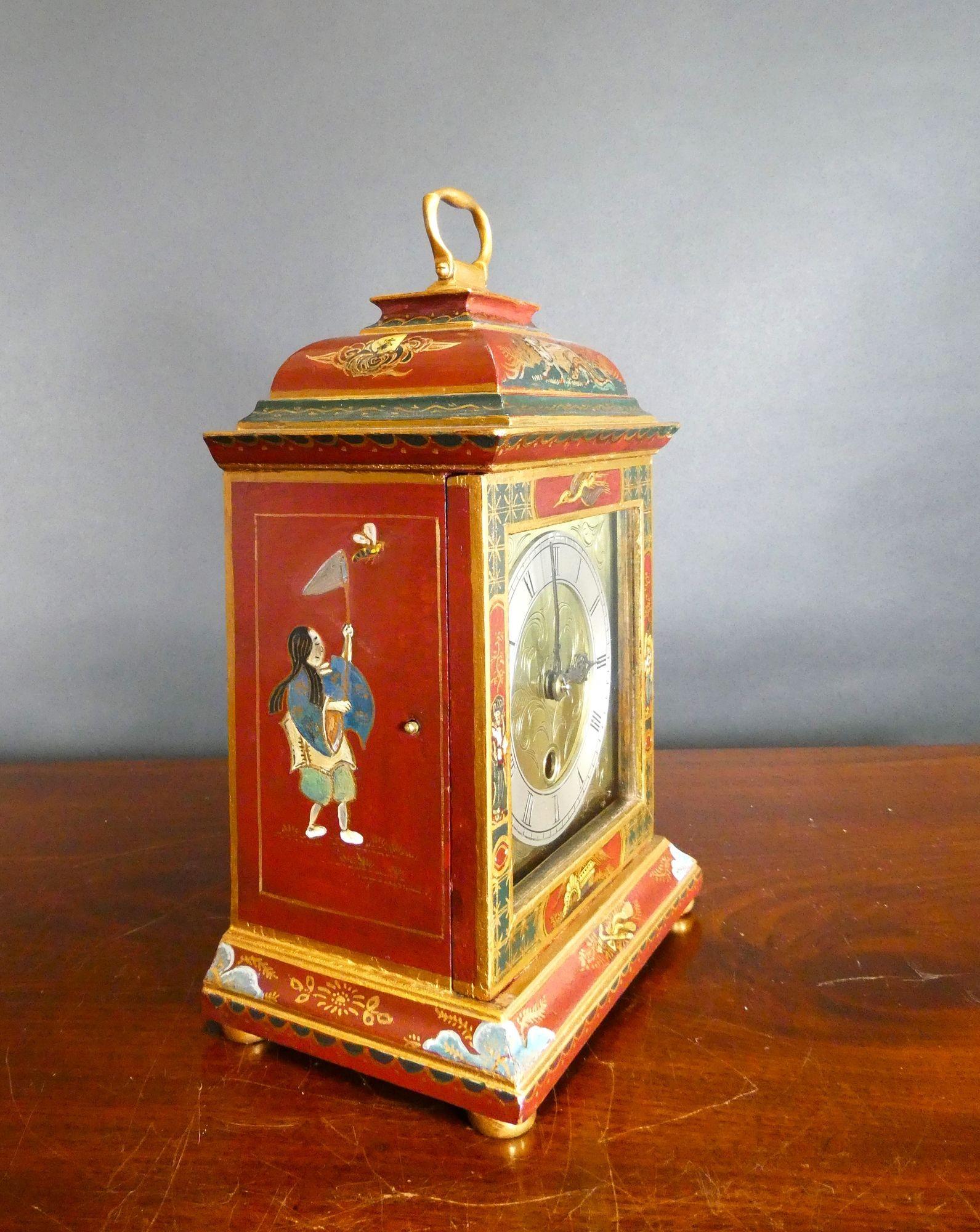 EDWARDIAN MANTEL CLOCK

Edwardian mantel clock housed in a chinoiserie decorated case with typical Chinese scenes on a red ground, standing on a raised plinth and resting on brass bun feet, surmounted by a bell top with brass carrying