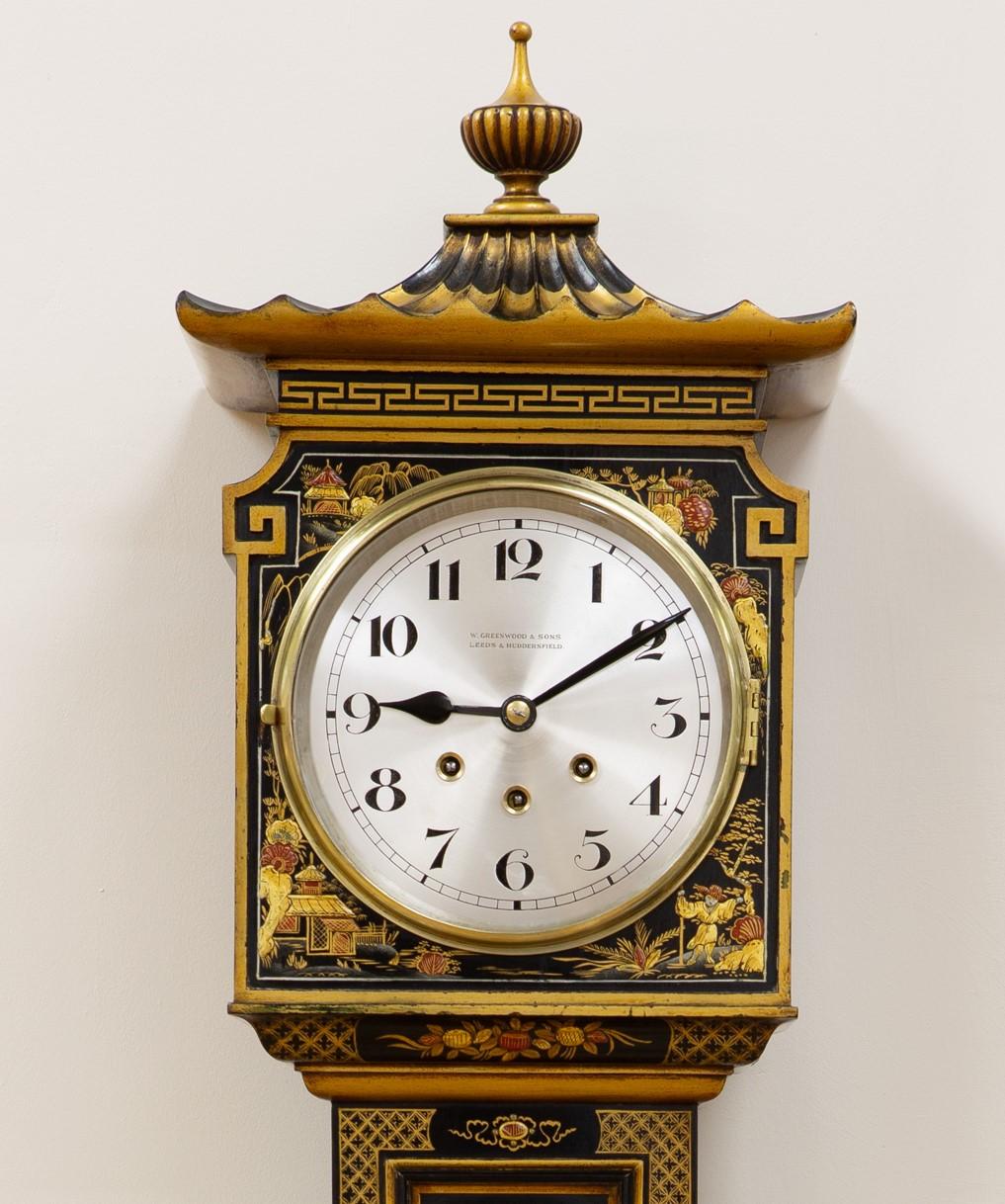 Elegant Grandmother clock standing on a raised, moulded plinth surmounted by a ribbed pagoda and central finial.

Beautifully decorated case with fine raised chinoiserie scenes on an ebonised ground.

Silvered dial with Arabic numerals signed