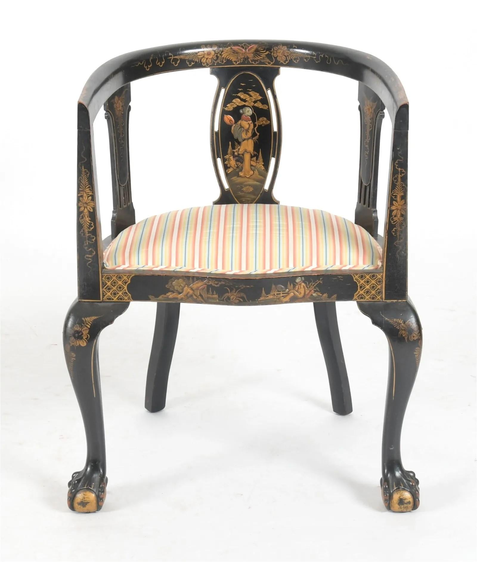 Beautiful pair of Chinoiserie Japanned gilt ebonized accent armchairs, Early 20th Century.  Curved rounded barrel back frames feature hand painted detailed scenes, classic ball and claw feet, and upholstered seats.  

