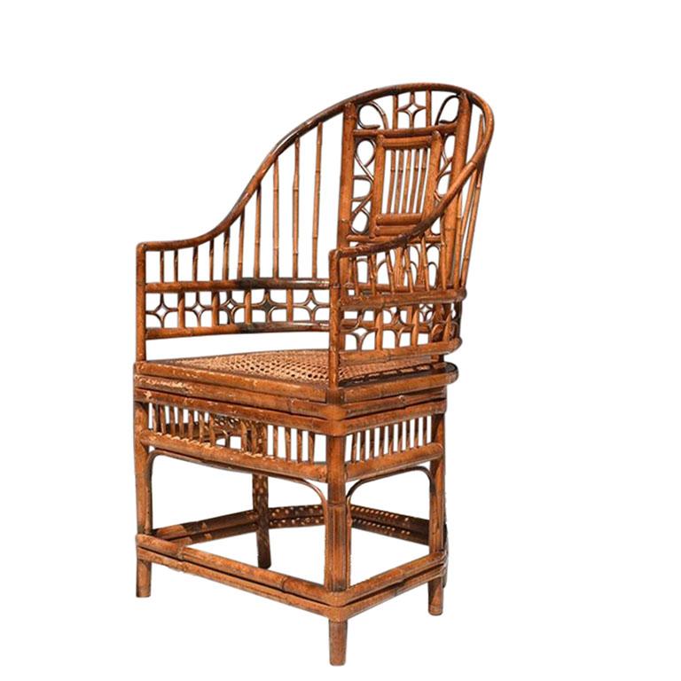 An early chinoiserie bamboo and cane armchair in the manner of Brighton Pavillion. A rare find, this timeless chair has a split frame and upright back. It features intricate inset geometric and foliate bamboo openwork on each side, and smooth down