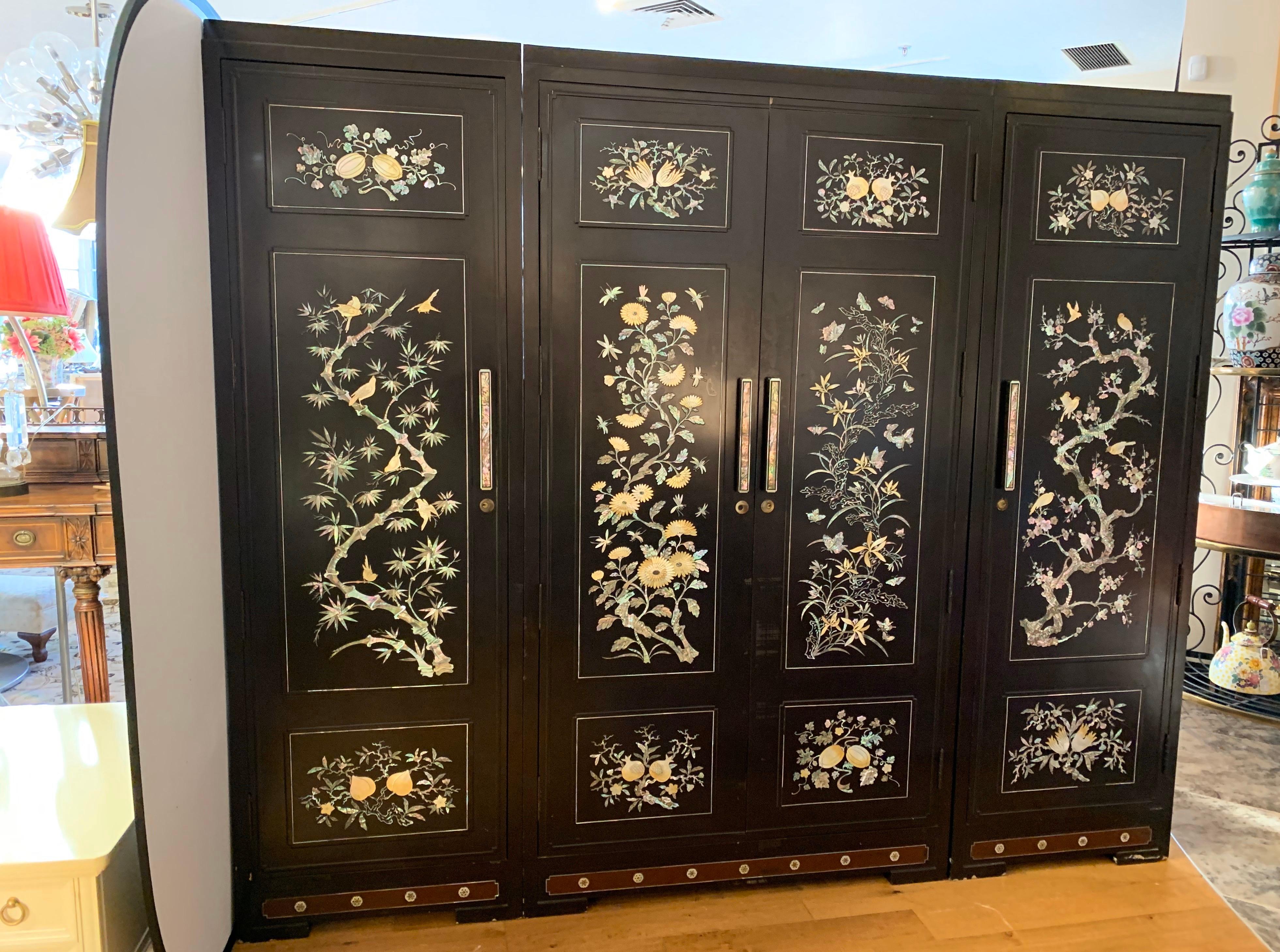 Extra large, three-piece chinoiserie black lacquer wardrobe cabinet complete with drawers and hanging rods.
Not enough closet space in your home, no problem! Features mother of pearl throughout. Interior is black lacquer with red undertones. The