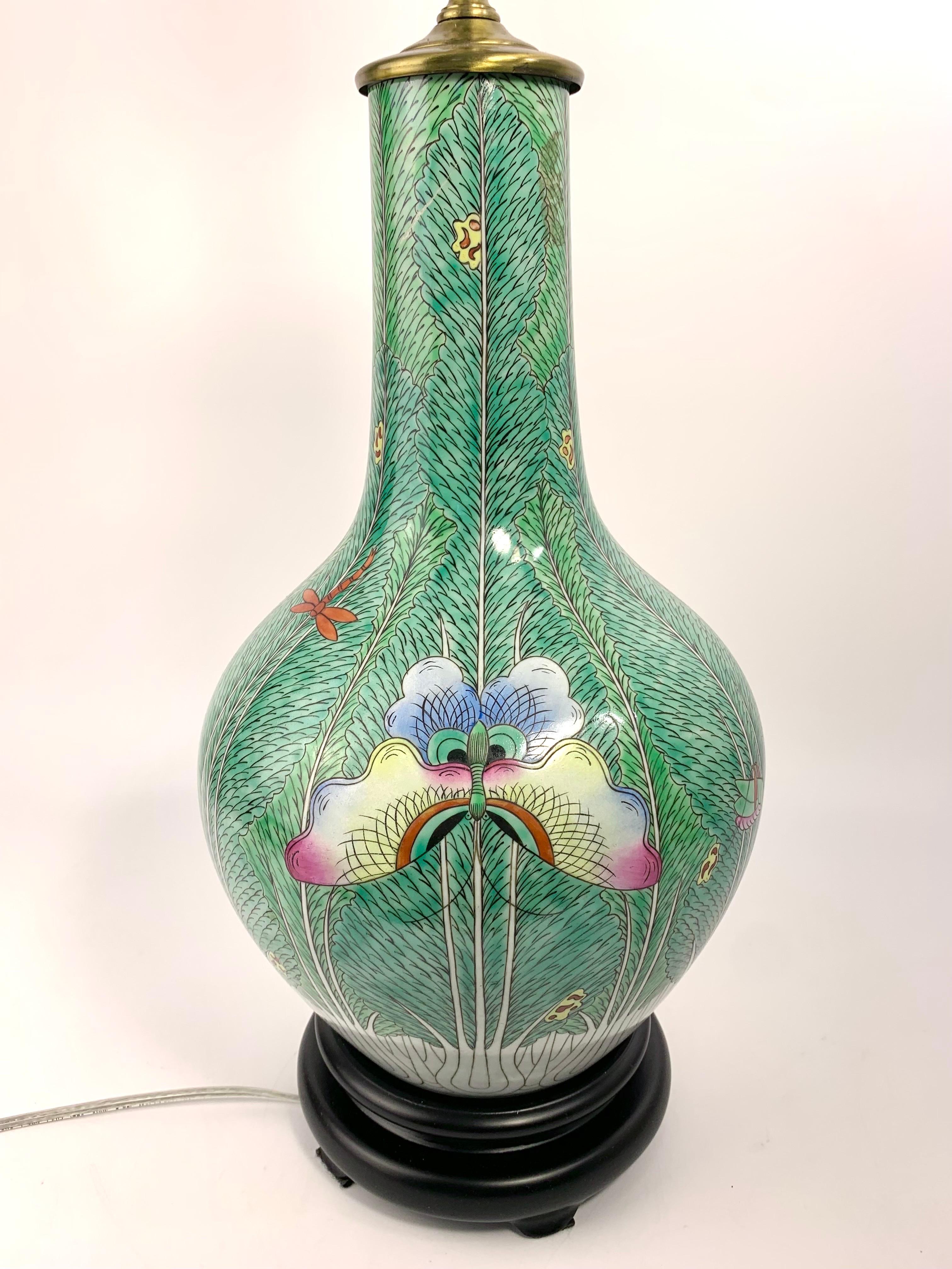 Beautiful famille verte green bok choy ceramic vase table lamp with brass fittings and a wood base. Colorful hand painted butterflies, grasshoppers, and other insects. 

Measures about 32” height x 8.5” diameter.