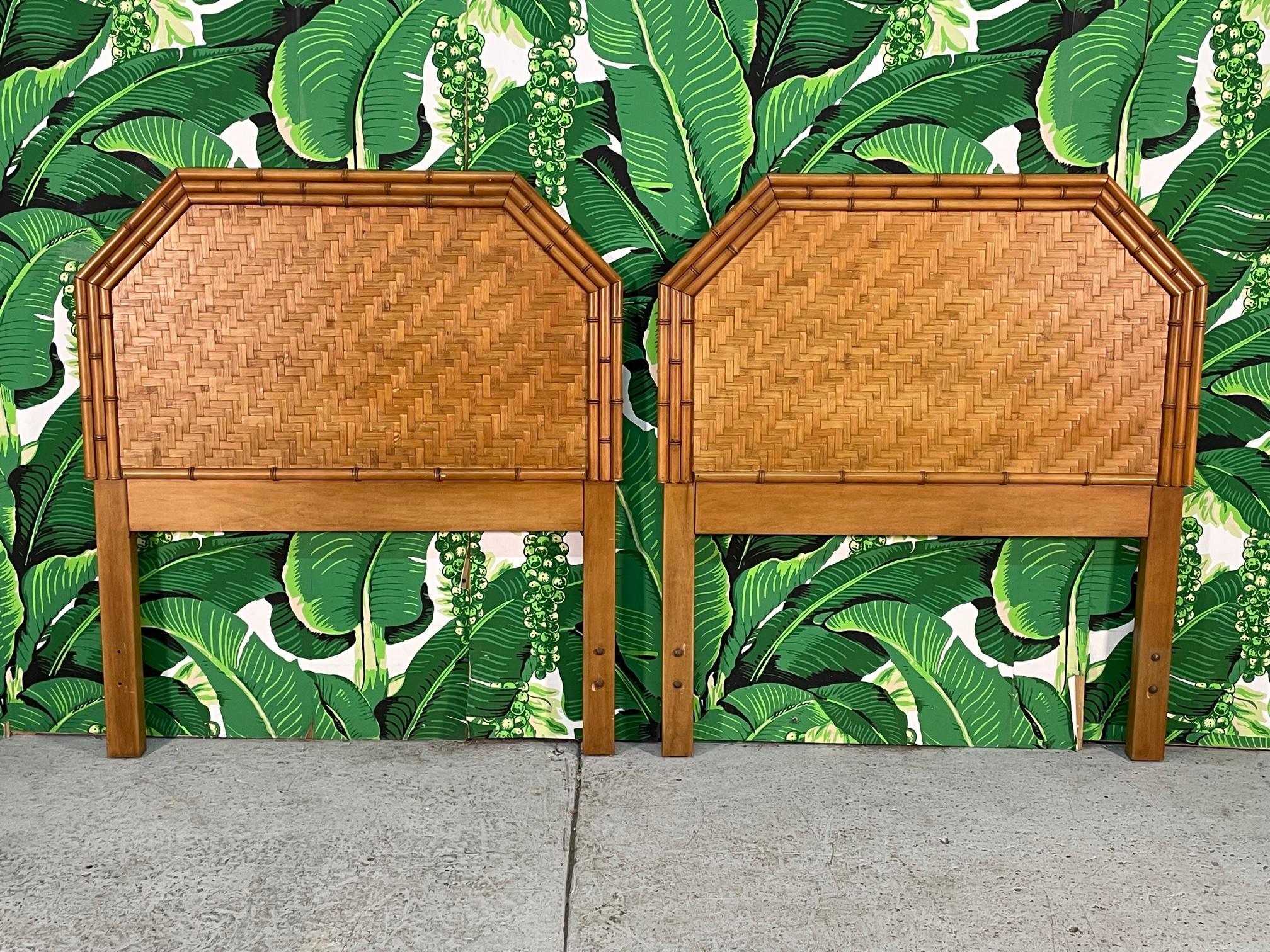Vintage pair of twin headboards feature faux bamboo detailing and a complete veneer of woven rattan basket weave in a herringbone pattern. The unique rattan veneer gives a look of parquet. Reminiscent of designs by Bielecky Brothers. Warm, rich tone