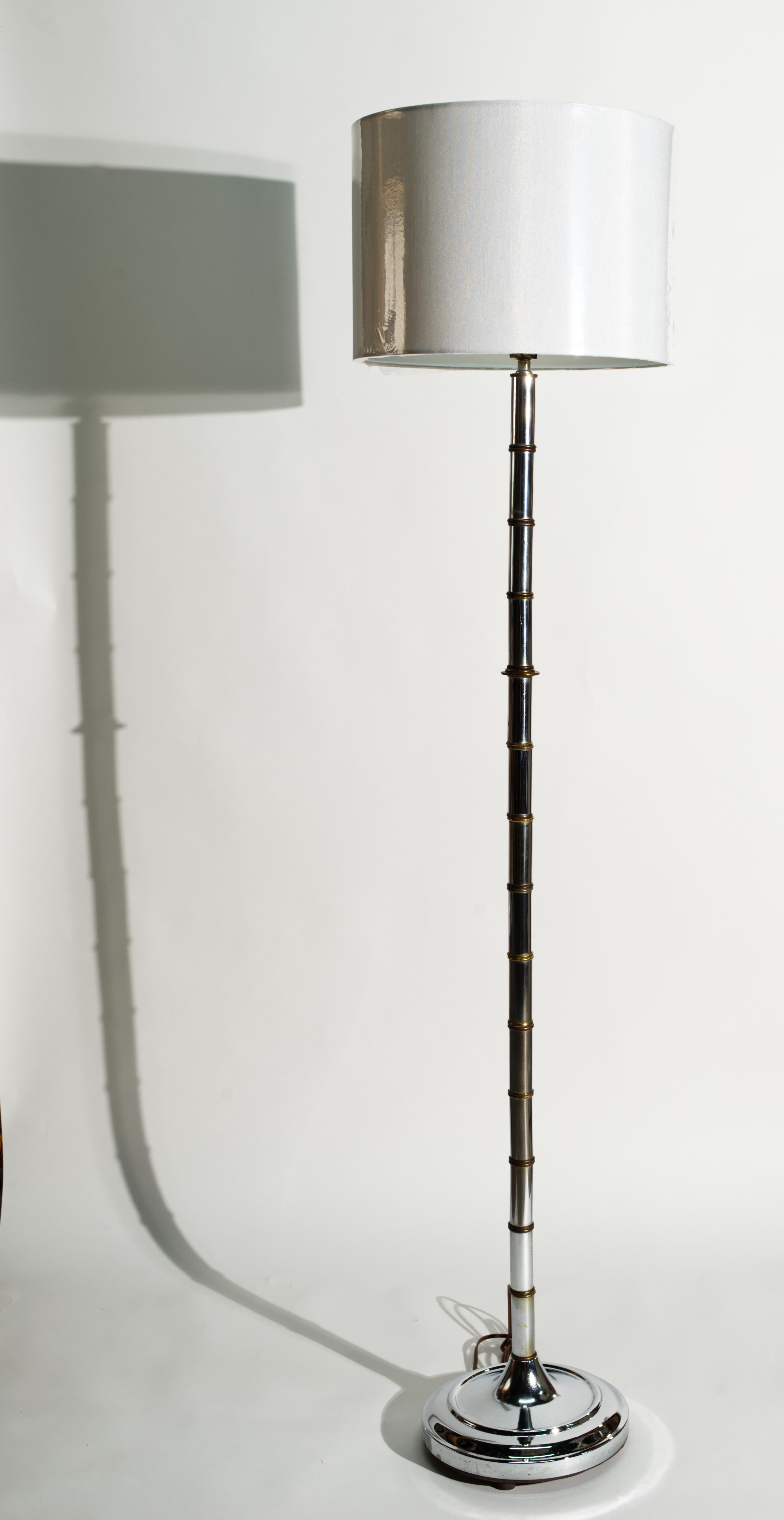 Vintage Chinoiserie floor lamp or torcher features stylized faux bamboo body in chrome and brass and textured round chrome base. A combination of mixed materials and elongated form are lending texture and sophistication to the design.

The lamp is