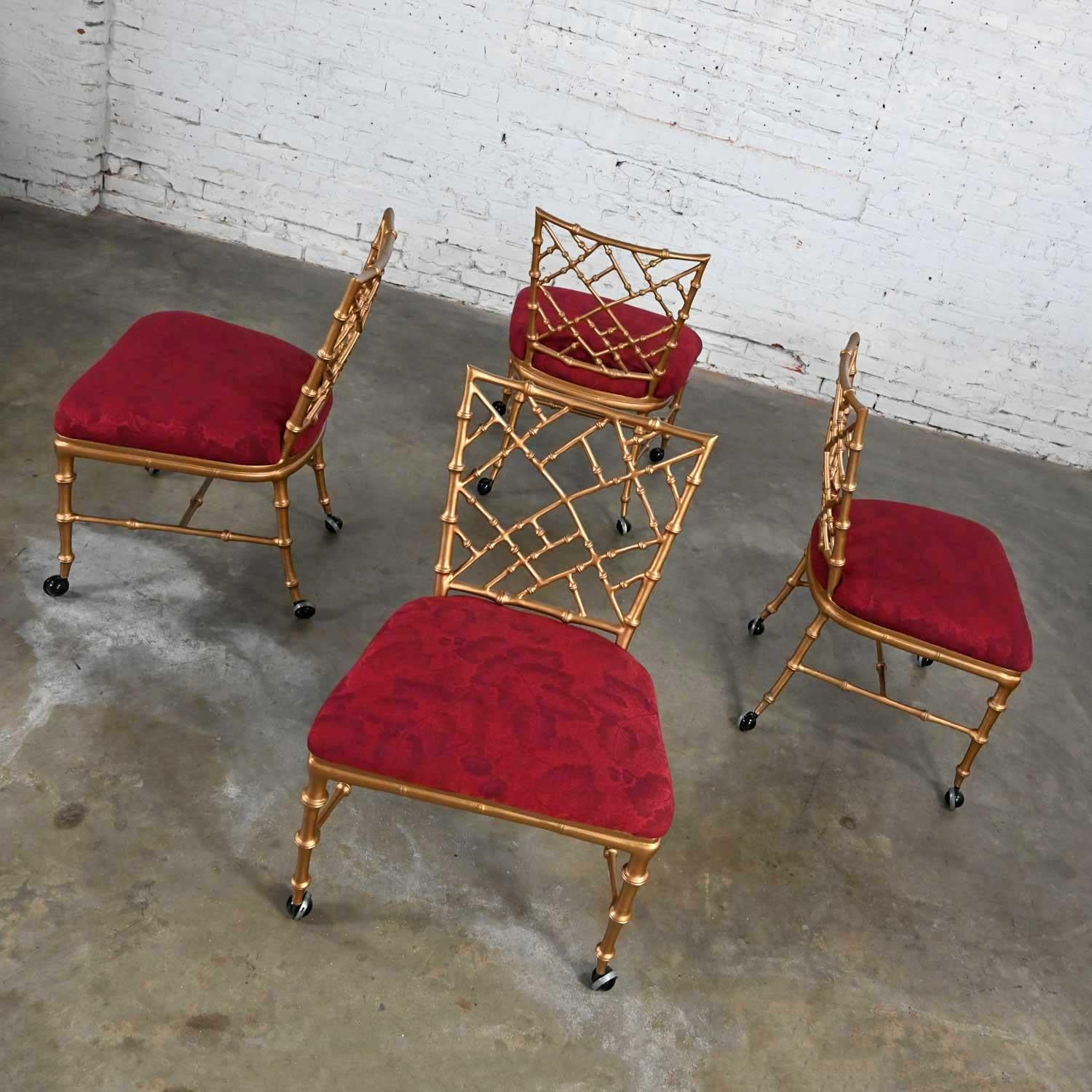 Stunning vintage Chinoiserie or Hollywood Regency faux bamboo gold painted metal rolling chairs on black casters with burgundy seats in the style of Phyllis Morris. Beautiful condition, keeping in mind that these are vintage and not new so will have