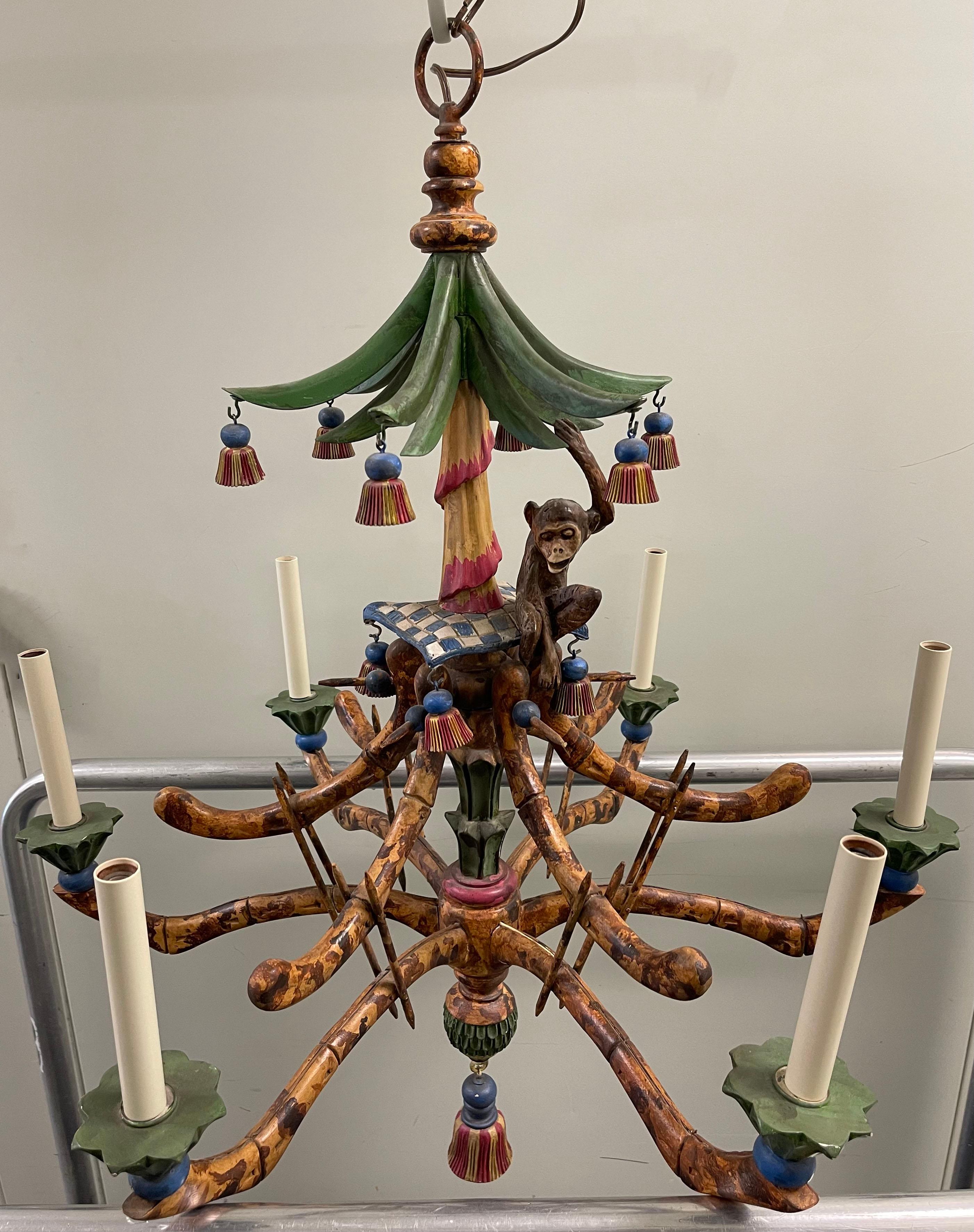 Chinoiserie faux bamboo custom faux painted chandelier. Tassel accents and hanging monkey figurine. Takes six chandelier bulbs (not included). Chain and 20