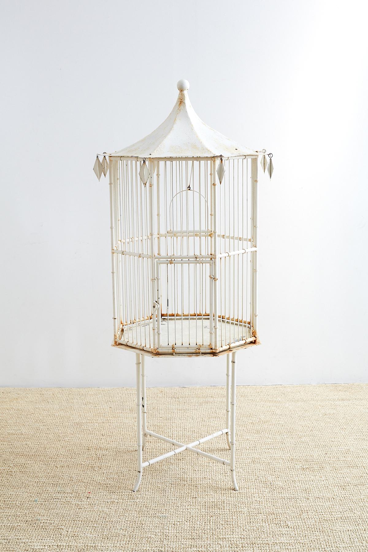Fantastic faux bamboo pagoda birdcage made in the chinoiserie revival taste of the early 20th century Europe. Constructed from wrought iron featuring a decorative faux bamboo motif and topped with an octagonal Chinese pagoda style roof. The roof has