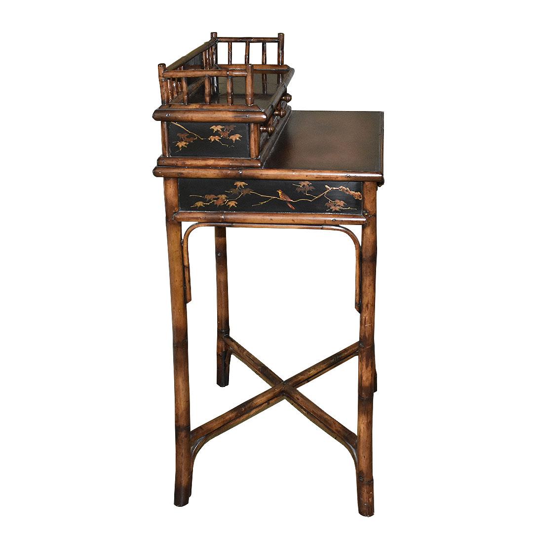 A fine chinoiserie faux tortoiseshell handmade wood and bamboo desk with drawers and leather top. A rare find, it is in superb condition and a true testament to the craftsmanship of the 1800s. A small ledge at the top of the piece is decorated with