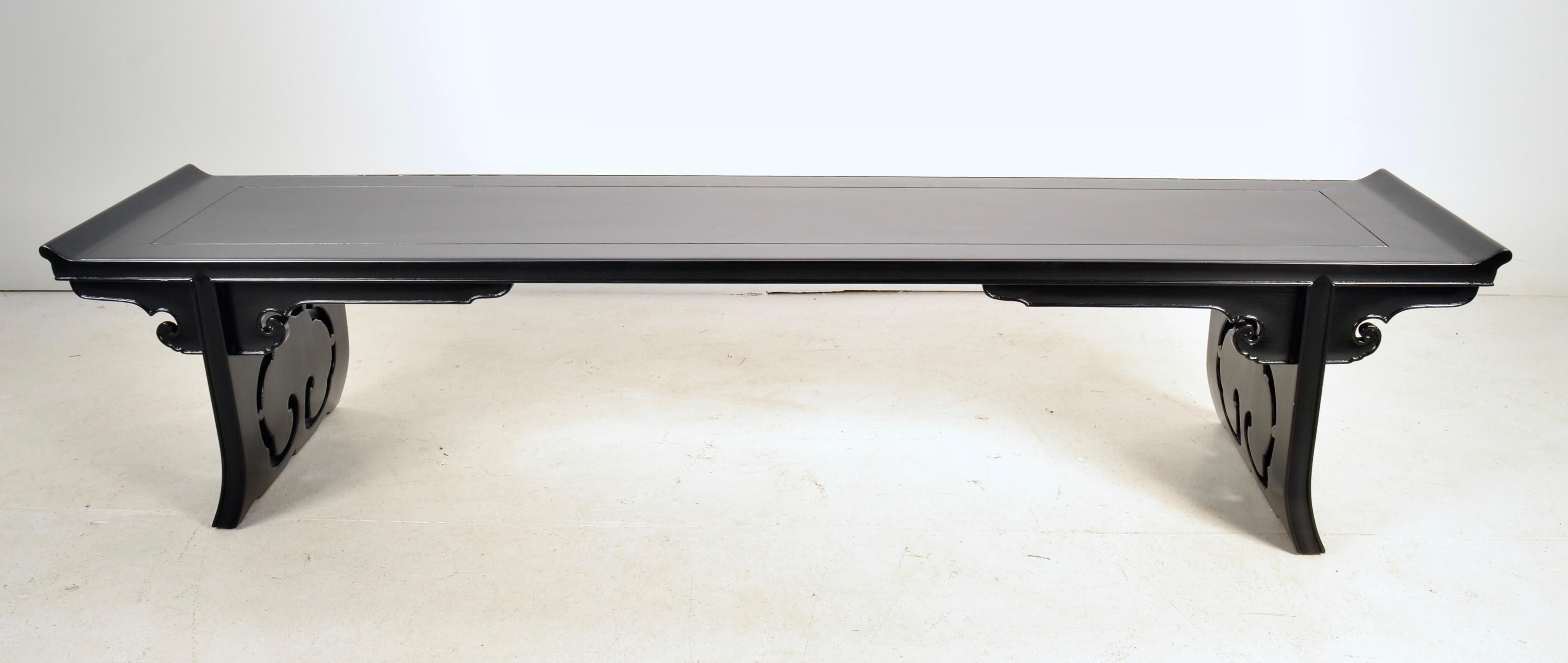 Striking long bench in Chinoiserie style, featuring classic Chinese-style pierced ends with decorative design. This bench has been newly lacquered in satin black so is in very fine condition. 