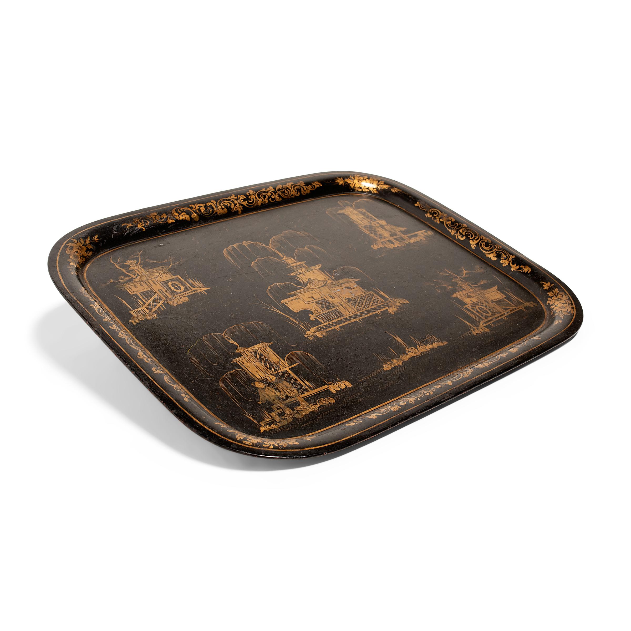 This large metal tray dates to the early 20th century and is decorated with a gold-and-black design in the Chinoiserie style. A black lacquer finish cloaks the rectangular tray on both sides and offers the perfect canvas for a gilt garden landscape.