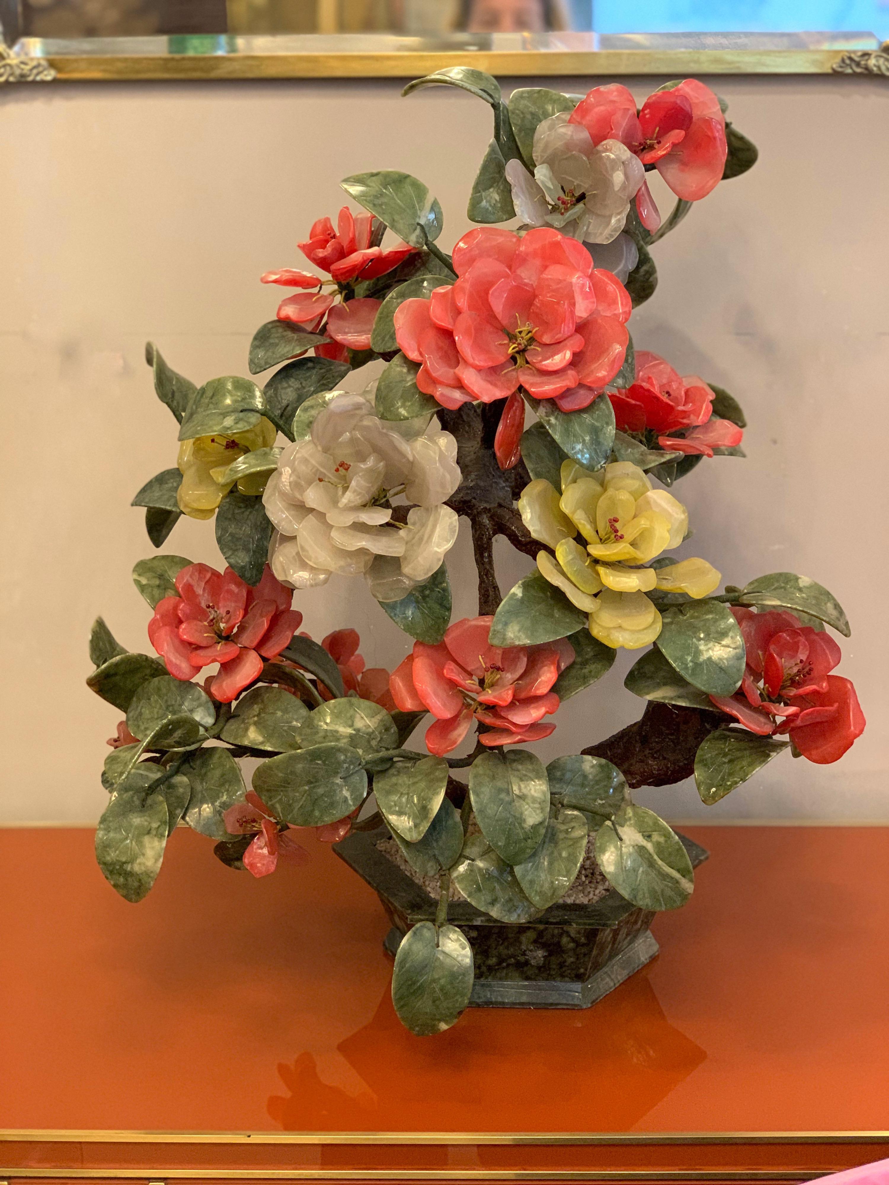 Chinoiserie jade onyx and quartz stones bonsai tree. Its faux bois tree trunk is firmly planted in a green granite pot, and every leaf and flower petal has been exquisitely carved. The leaves are of a jade green color stone, and the petals are in
