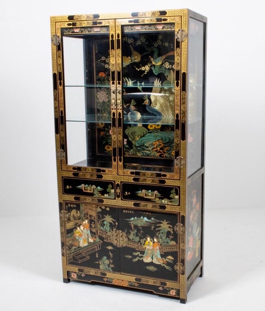 An exquisite and highly ornate Chinoiserie cabinet with glossy black lacquer, hand painted throughout with gilt and polychrome enamel motifs including peacocks, flowering trees, landscapes, and courtly scenes. Why not own the best?