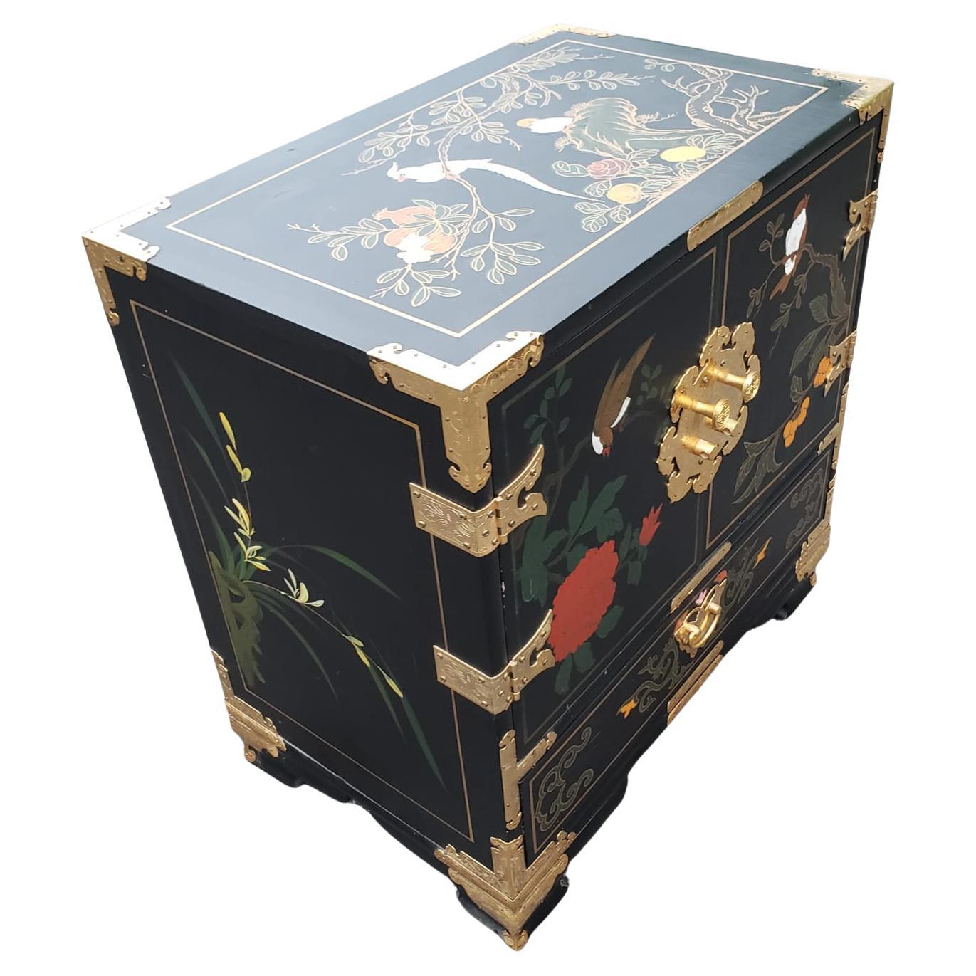 Small black lacquered chinoiserie cabinet features handpainted motif of birds and flowers on the top and sides and brass hardware. Front doors open to storage and three small drawers. 
In very good vintage condition.


W6053022

