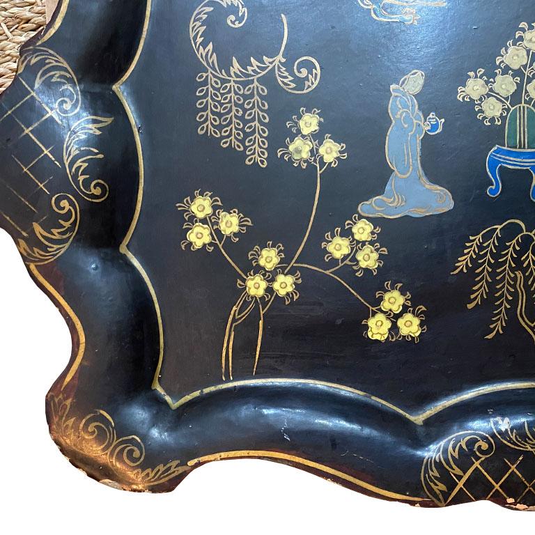 A fine chinoiserie japanned serving tray with a floral and figurative motif. This beautiful tray will be perfect for serving drinks at your next cocktail party. Created from papier mâché (or paper mâché) the sides are scalloped, with rounded