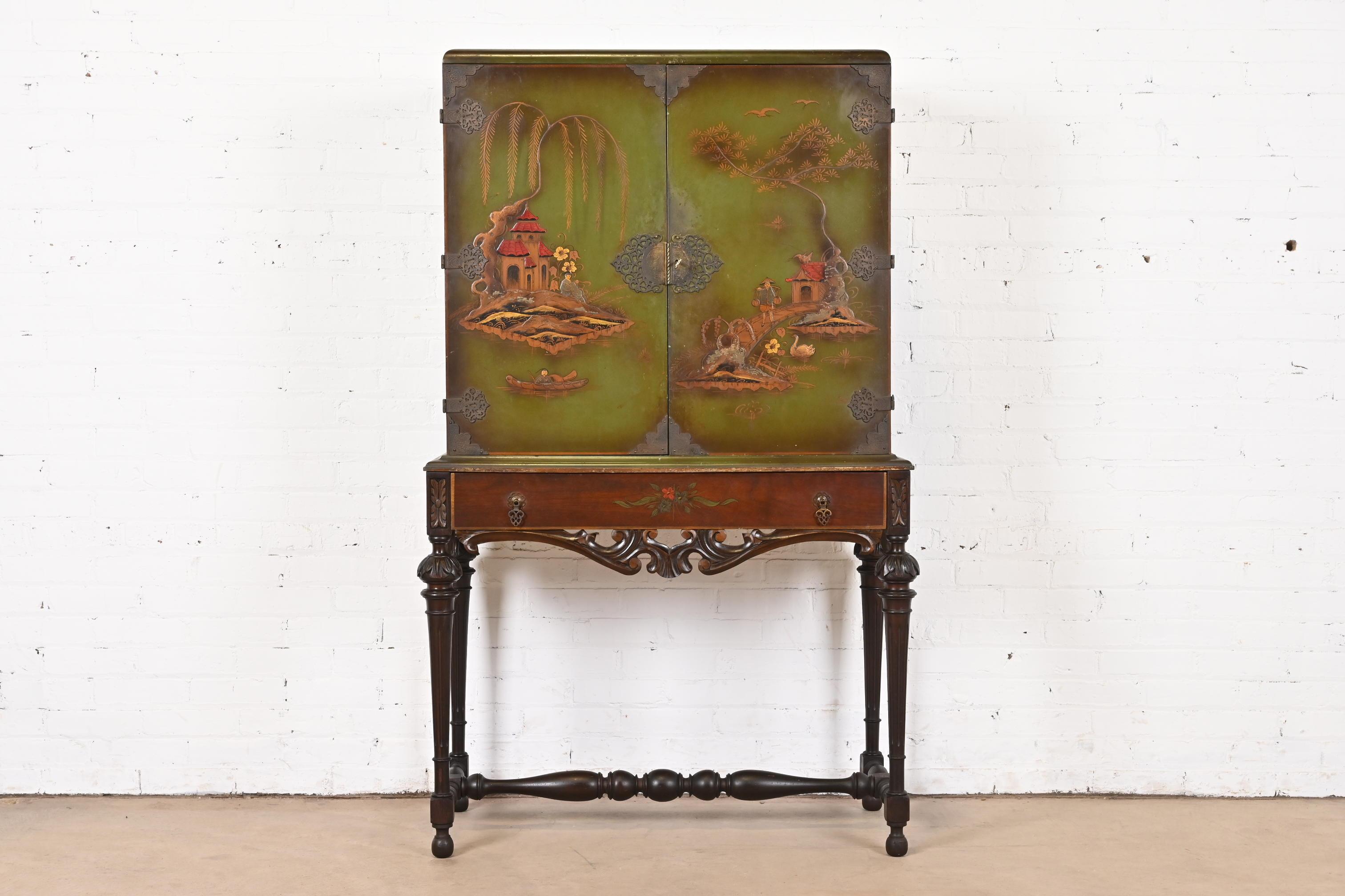 A gorgeous Chinoiserie Jacobean style bookcase, dining cabinet, or bar cabinet

In the manner of Berkey & Gay

USA, Circa 1920s

Carved walnut, green lacquered case with hand painted Chinoiserie scenes, and original brass hardware. Cabinet locks,