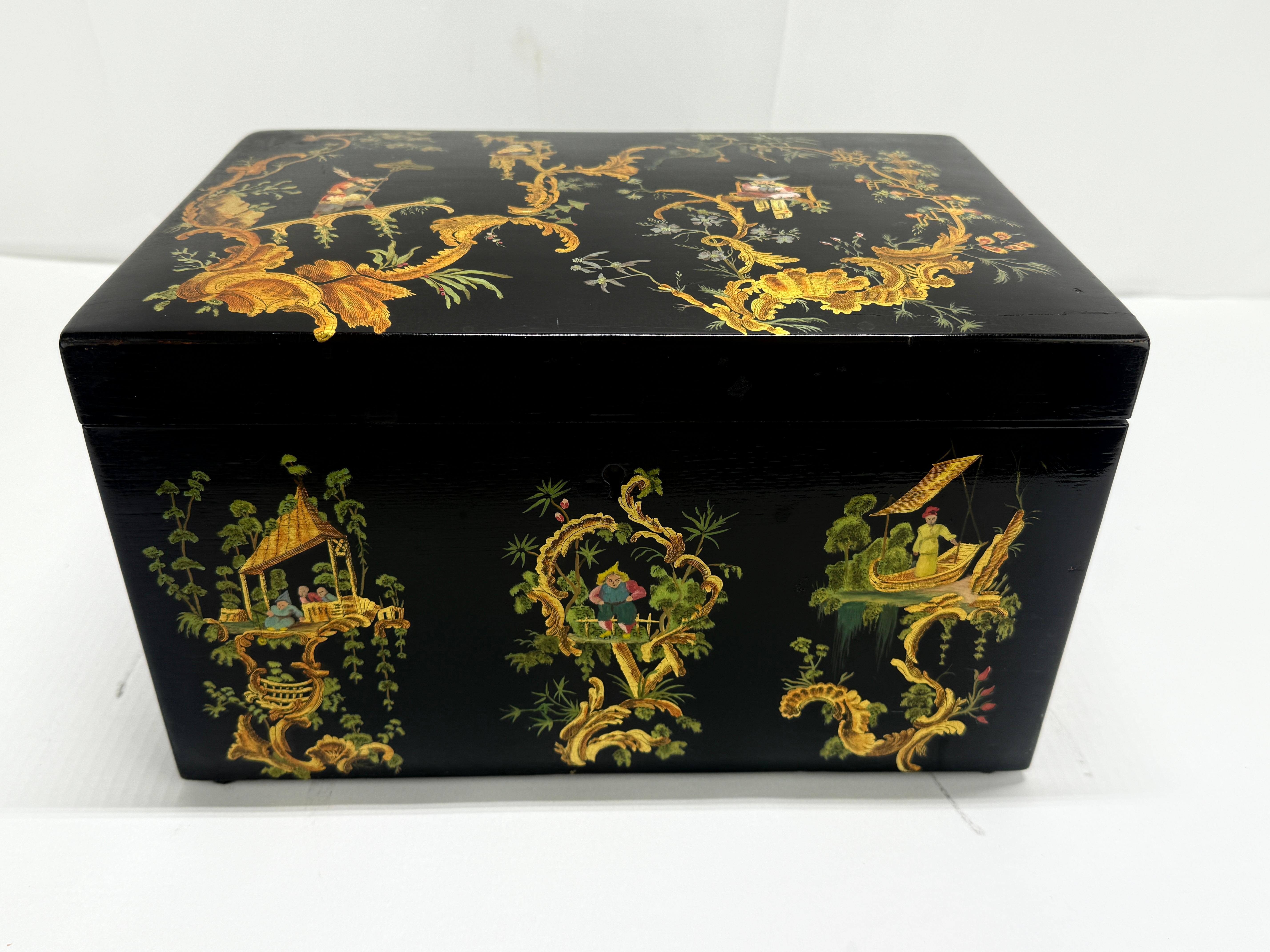 Un humidor in legno laccato e riccamente decorato secondo il nuovo stile della Chinoiserie, con l'esterno rifinito con una profonda japanning nera e finemente dipinto con volute rocaille dorate che incorniciano piccole vignette figurative. Ogni