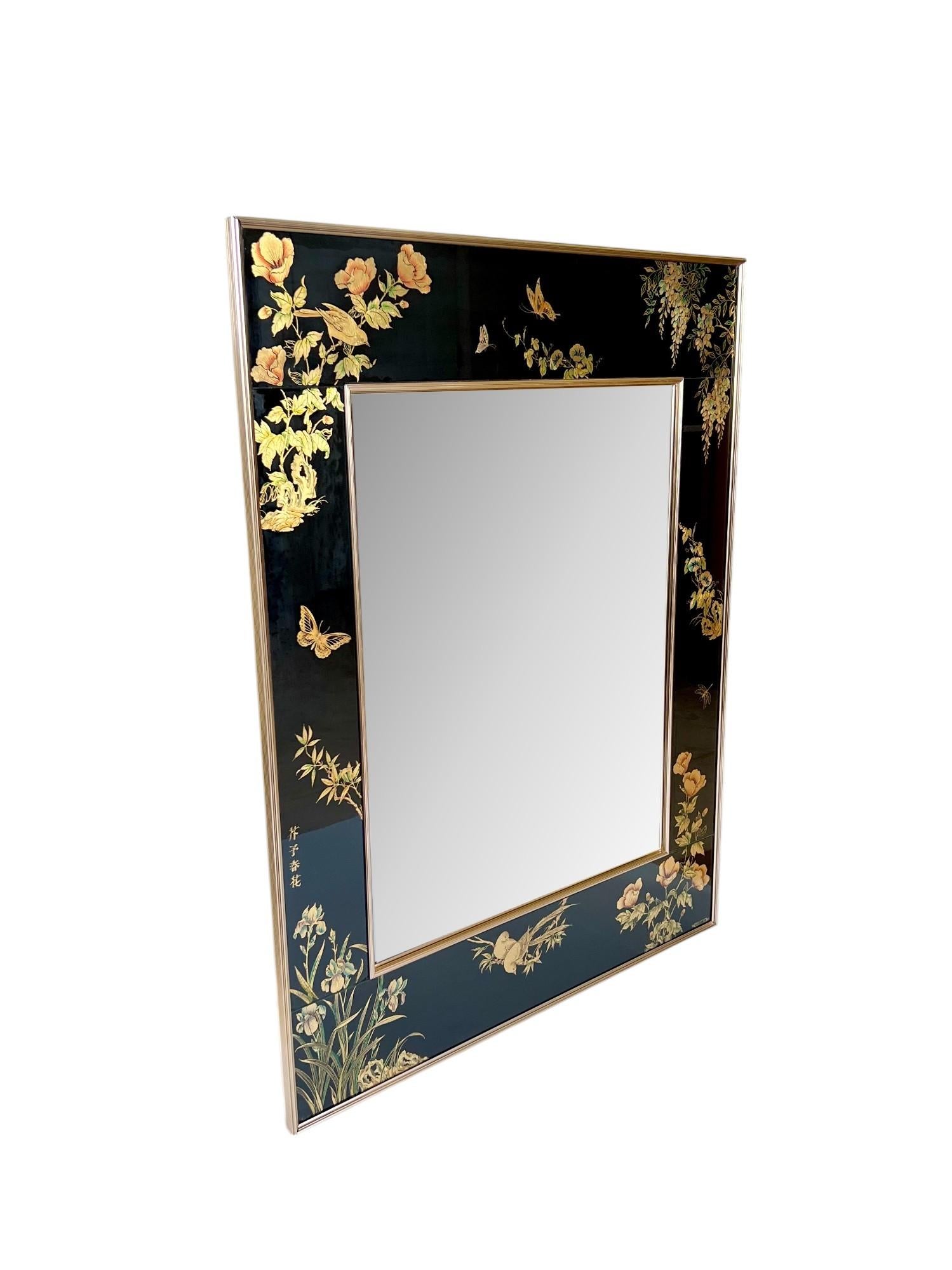 An exquisite late 20th century chinoiserie style La Barge reverse hand painted and gilt glass wall hanging mirror, signed and dated 1986. It features a gorgeous verre églomisé application in floral, foliate and bird designs in gold leaf, green and