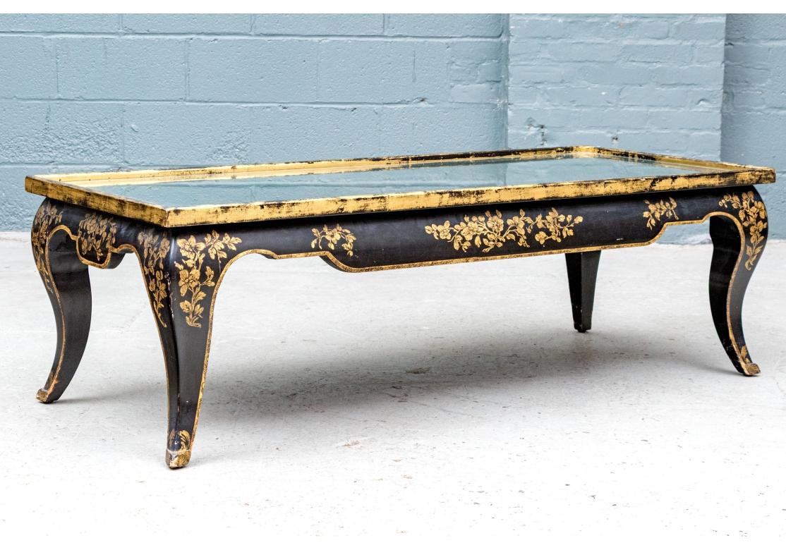 Ein eleganter niedriger Tisch im Chinoiserie-Stil mit einer besonders bemerkenswerten Form A  ebonisiert mit vergoldeten blühenden Bäumen und Enten auf dem Wasser auf der Oberseite. Vergoldete Blumenranken zieren die Längsseiten und Blumenbüschel an