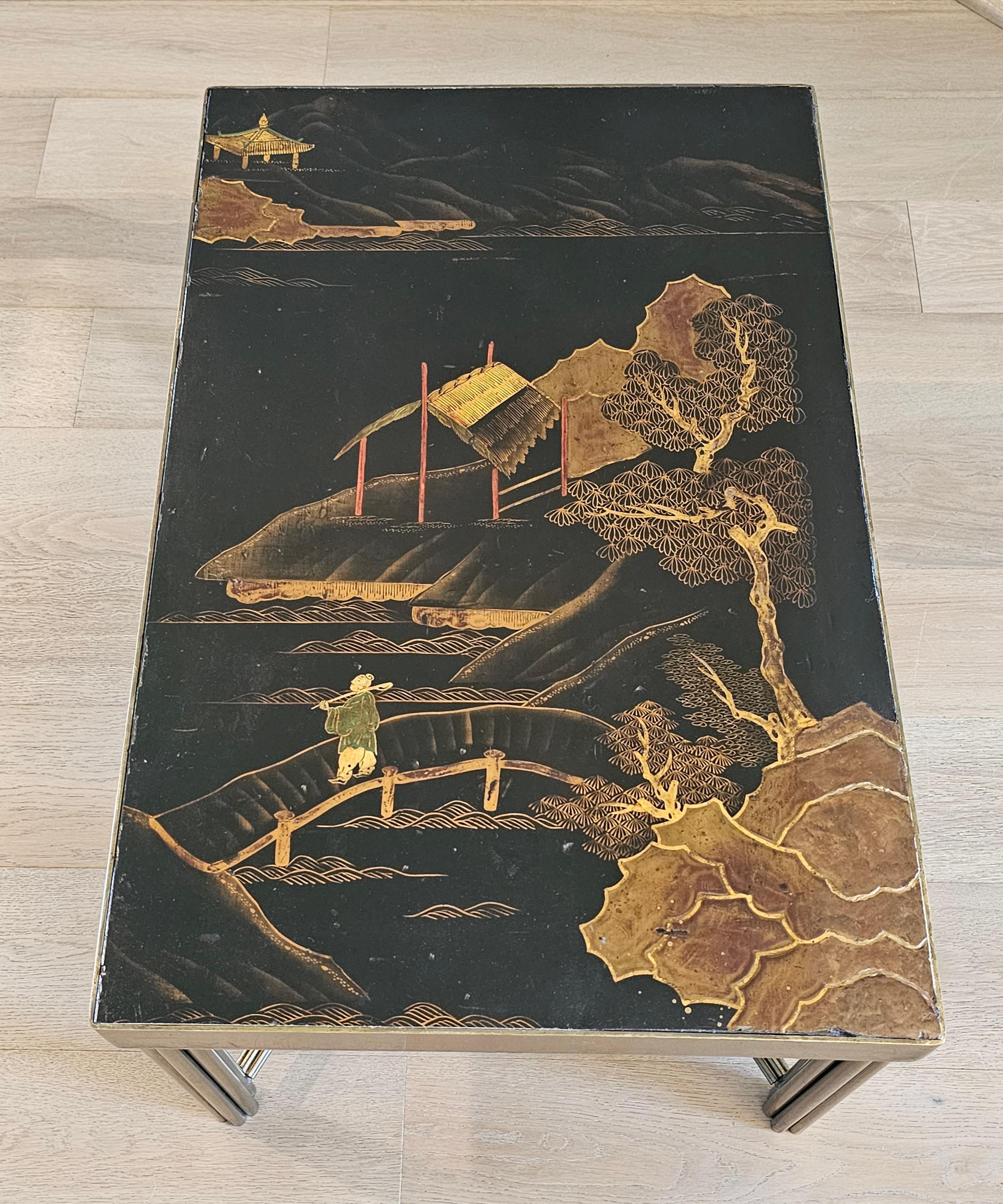 Remarquable table basse de style Chinoiserie française du milieu du siècle, à la manière de la légendaire Maison Maison Jansen. Le plateau est composé d'un panneau laqué à la main représentant des personnages et des paysages asiatiques, inséré dans