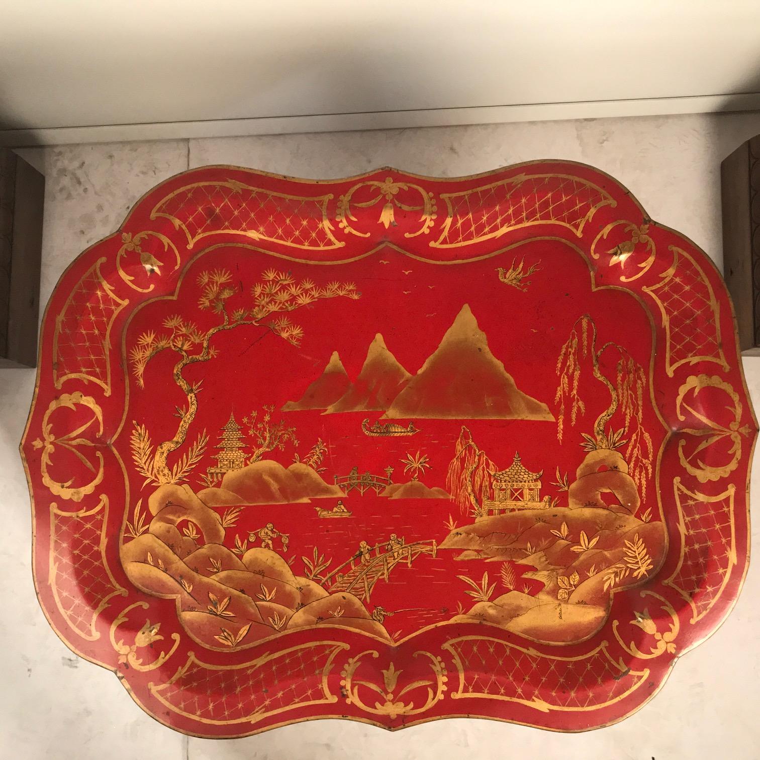 Dieses Tablett ist ein englisches viktorianisches, gut vergoldetes Tablett mit einem Chinoiserie-Dekor aus Pavillons, Brücken und Fischern in einer ausgedehnten Berglandschaft in einem geformten und vergoldeten Rahmen. Scharlachrote Tabletts wie