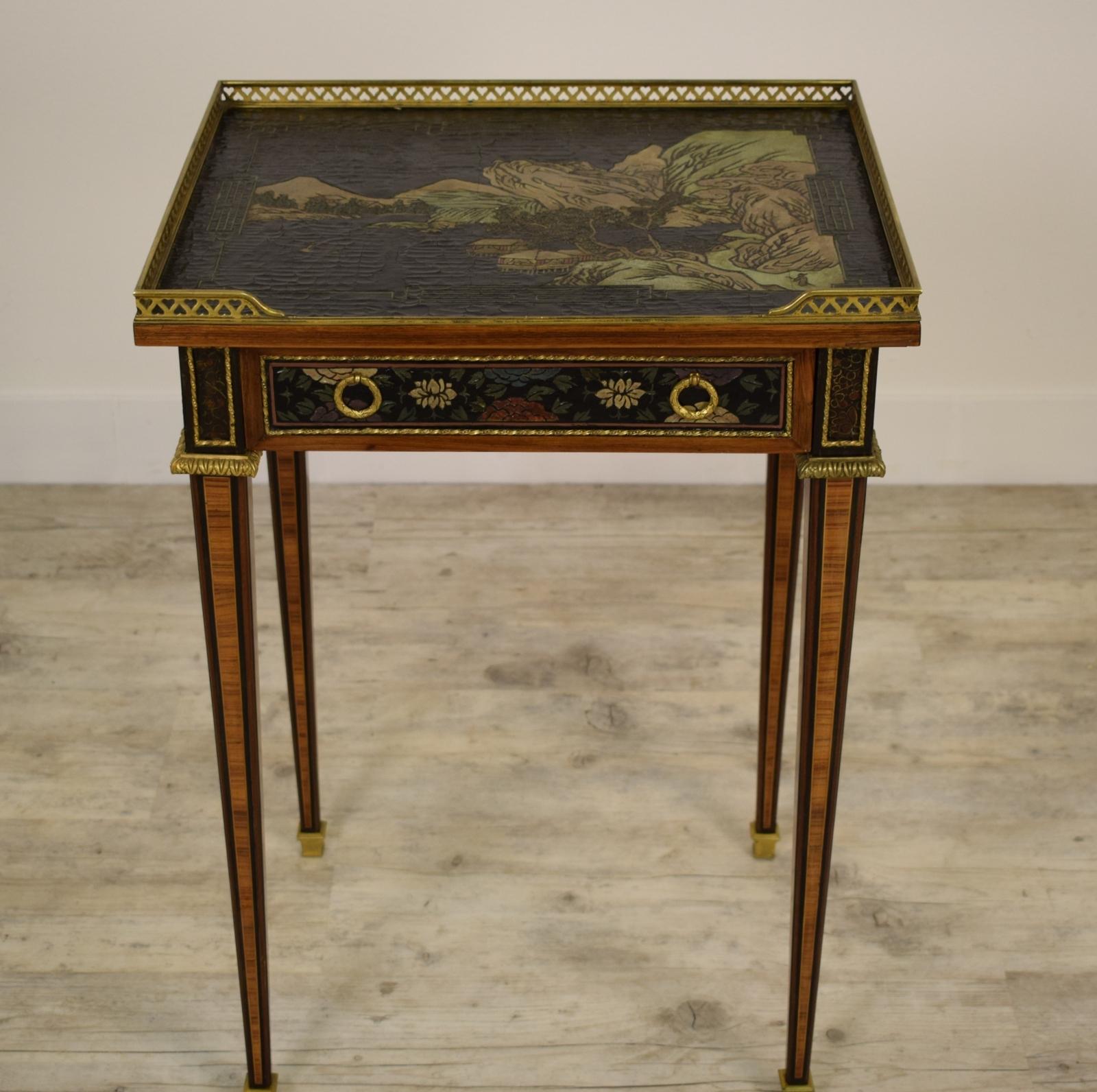 The table was made in France in the second half of the 19th century in the Louis XVI style. The wooden structure is entirely veneered and the top, as well as the band under the central and lateral top, lacquered with chinoiserie designs. On the