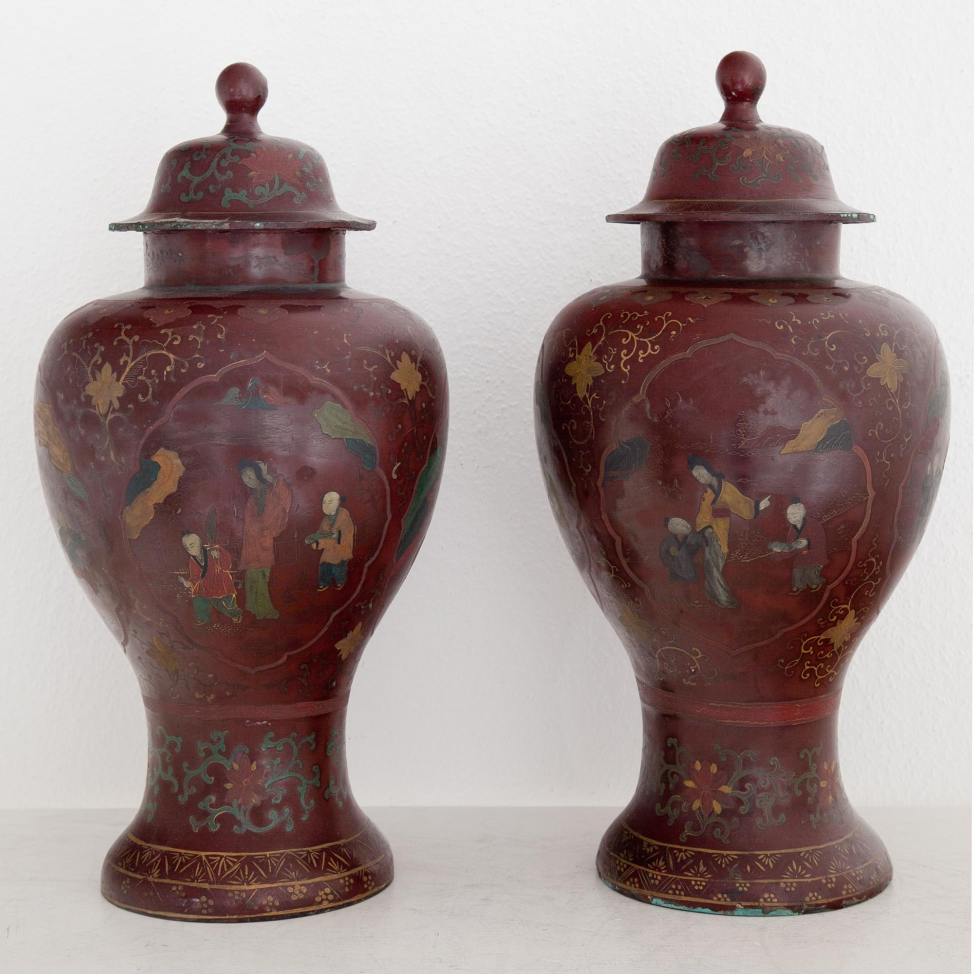 Pair of red lacquered metal urns with polychrome chinoiserie décor on the wall. Probably Berlin in the early 19th century. 
Measurements: 53 x Ø26.