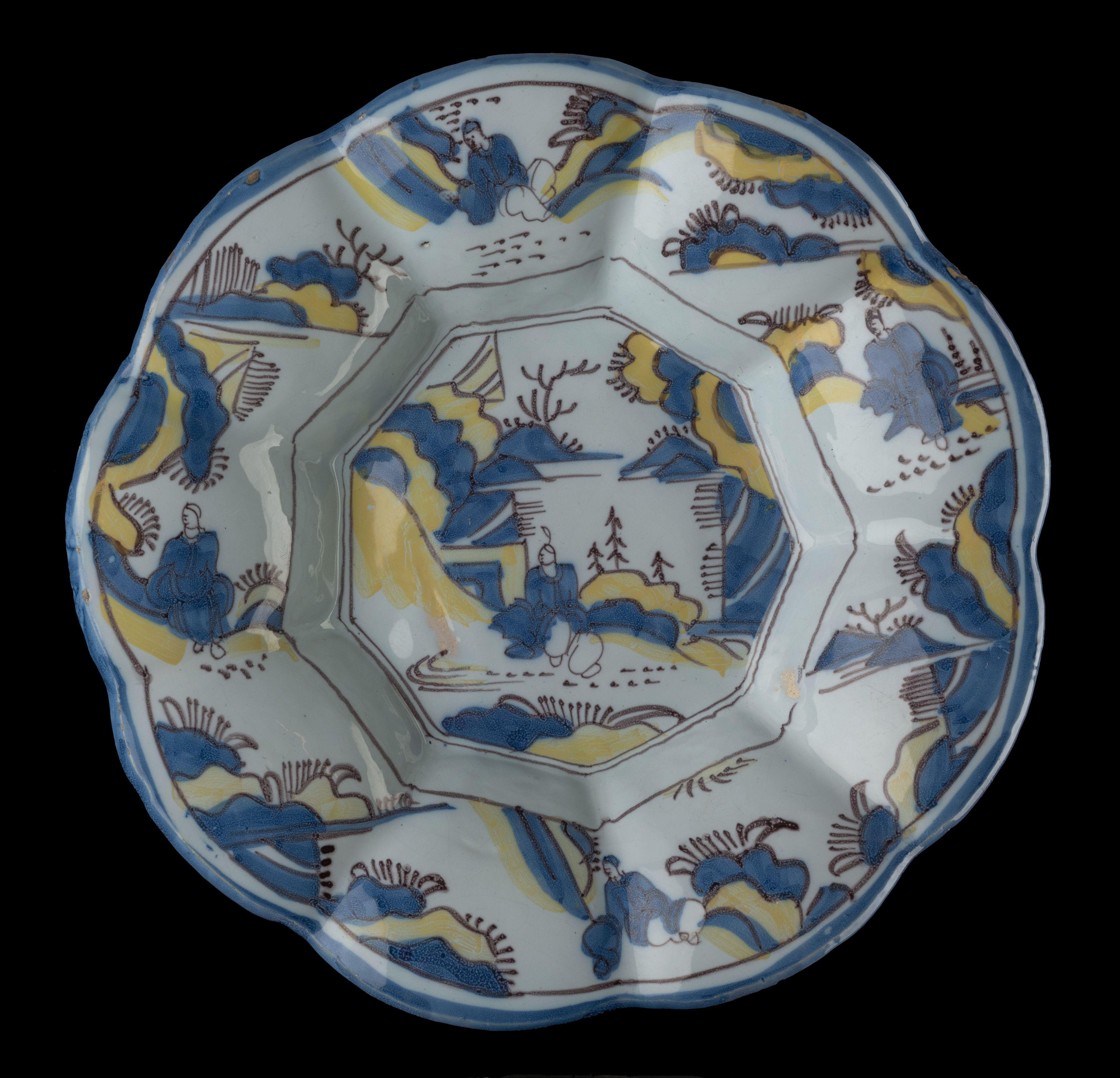 Chinoiserie lobed dish in blue, yellow and purple. Delft, 1680-1690
Dimensions: diameter 34 cm / 13.58 in. 

The lobed dish is composed of nine, wide lobes around a nine-fold centre and is painted in blue and yellow with a chinoiserie decor. A